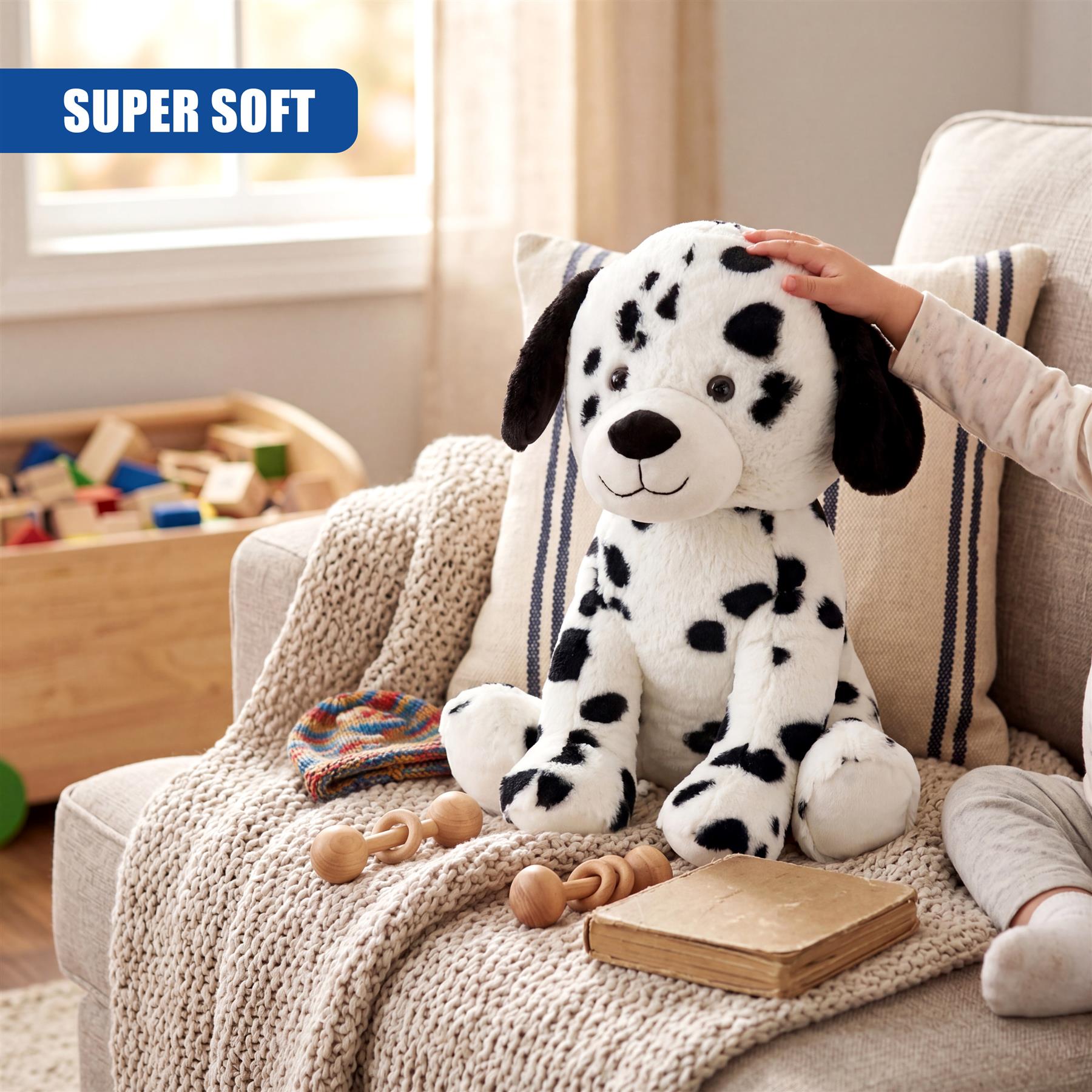 Dalmatian stuffed dog toy sitting on a beige couch with accessories.