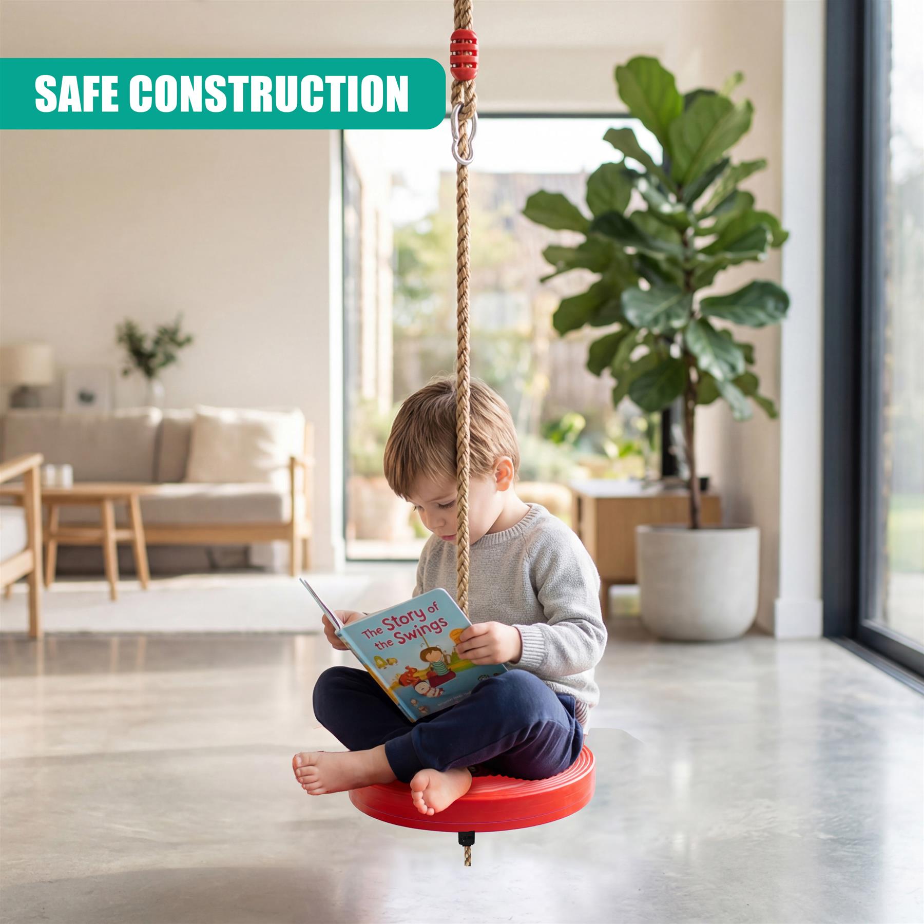 Red swing seat hanging from a rope; a boy sits reading a storybook indoors.