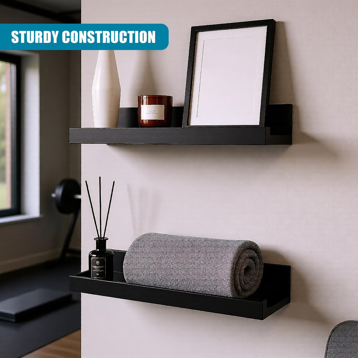 Black floating shelves, a set of two, display a picture frame and candle on a grey wall