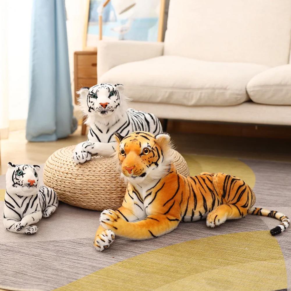 Three plush animal toys, including an orange tiger and two striped cats, are displayed on a rug.