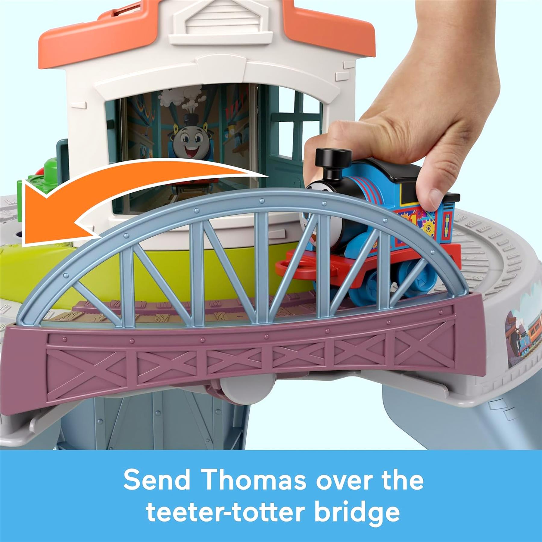 A train toy crosses a bridge structure featuring blue supports and pink outer railings.