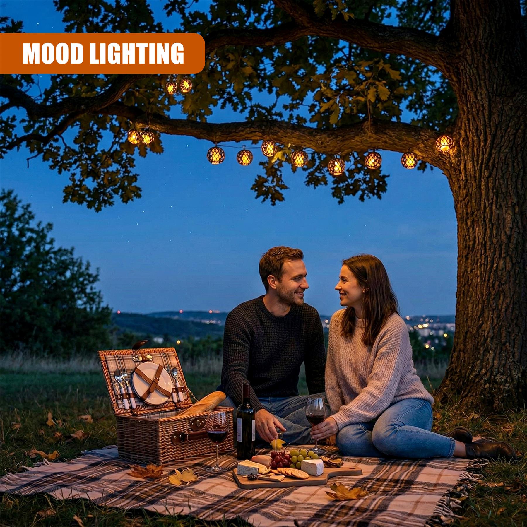 Rattan solar string lights illuminate a picnic set up under a large tree at dusk.