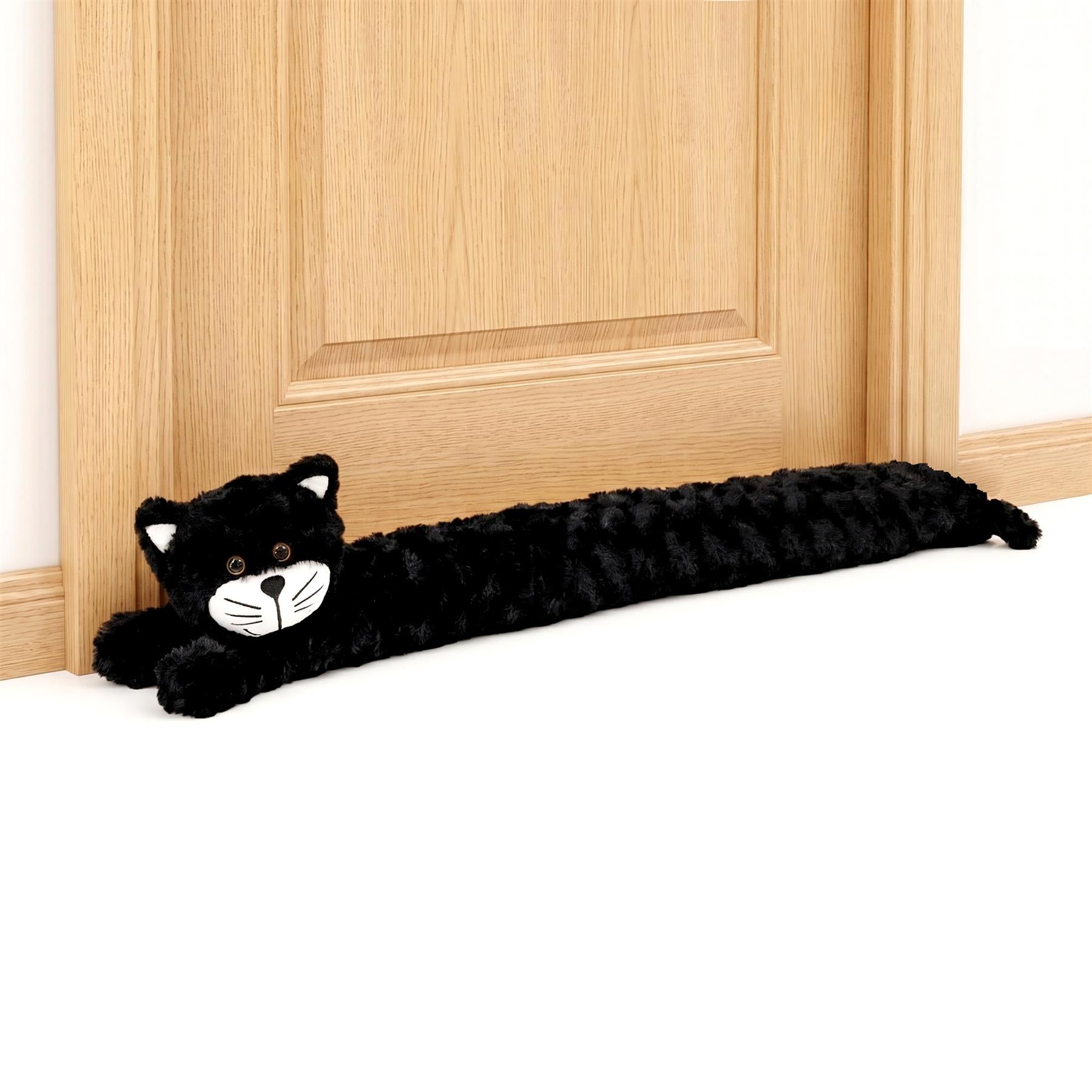 Black plush cat novelty draught excluder lying on a wooden surface.