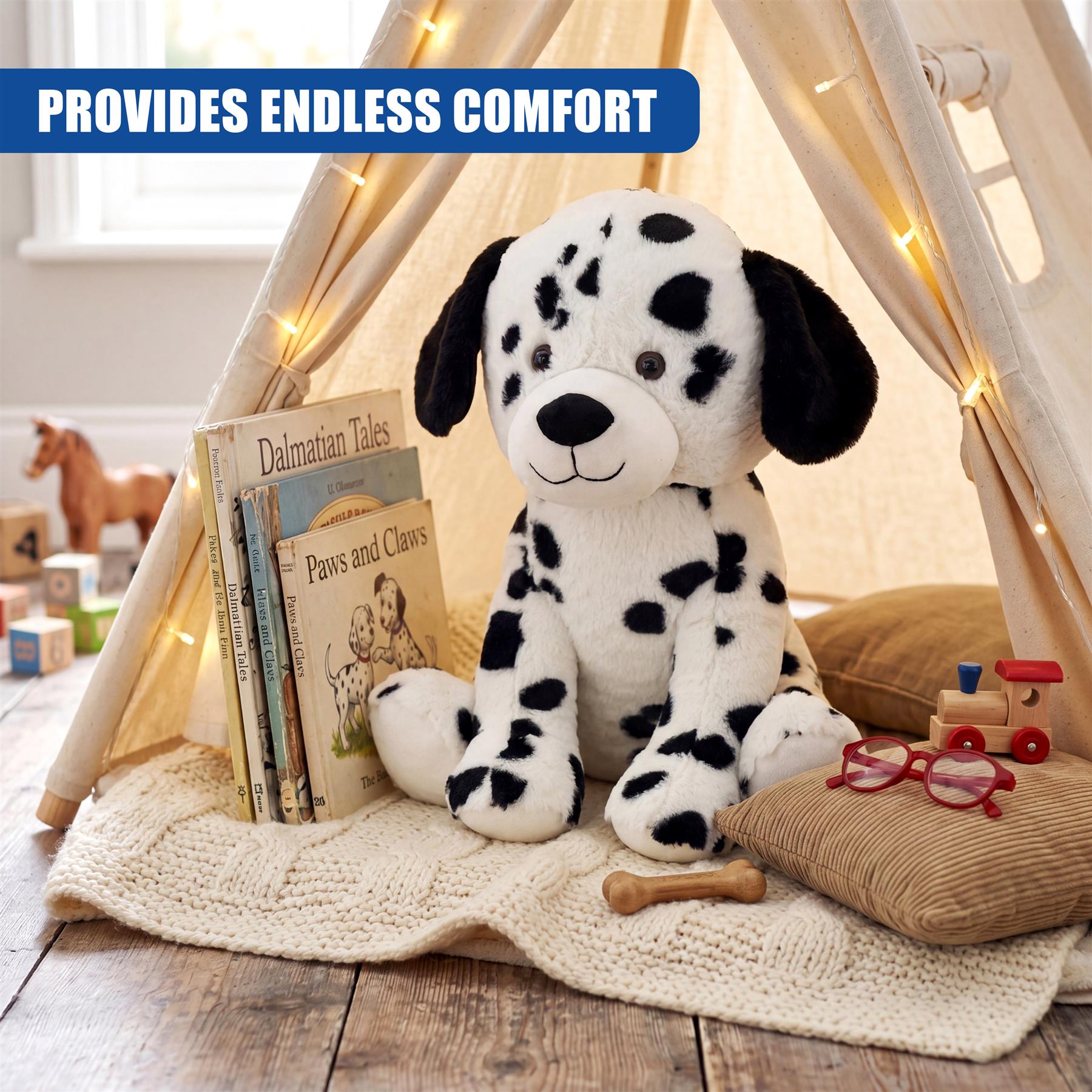 Soft stuffed Dalmatian toy displayed inside a teepee next to books, a wooden train, and bone.