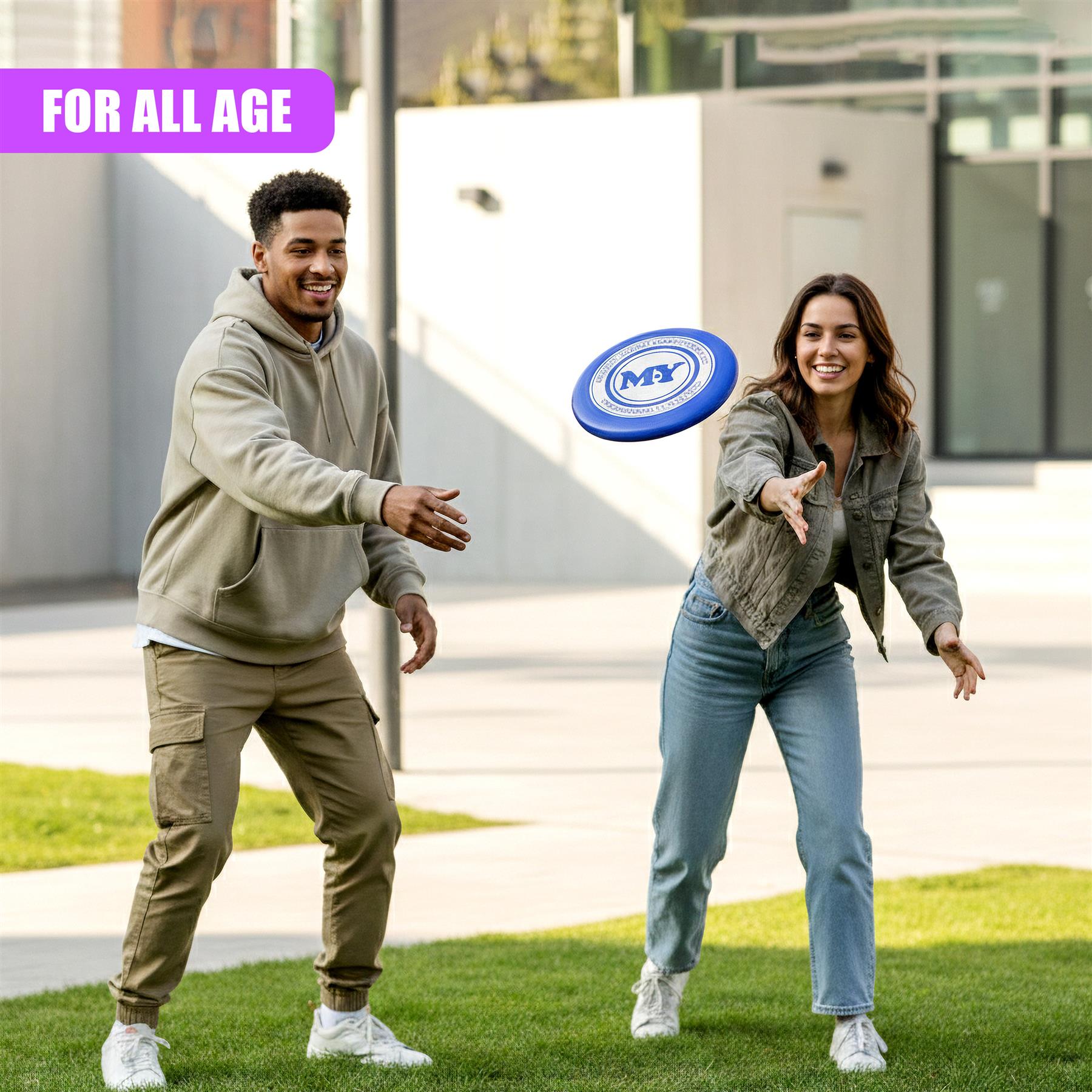 A man and woman smile while catching a blue and white frisbee outdoors.