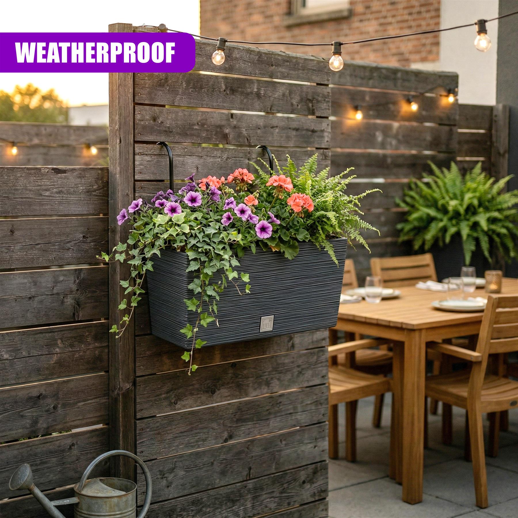 Dark gray rectangular planter filled with colorful flowering plants mounted on a wooden slat wall.