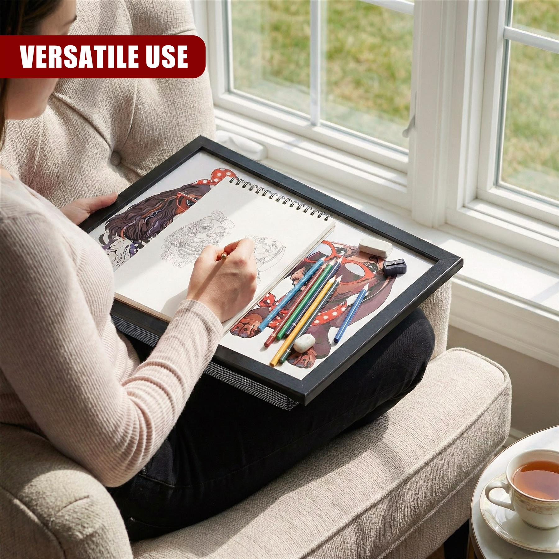 Open sketchbook and drawing pencils rest on a portable lap tray placed on a couch.