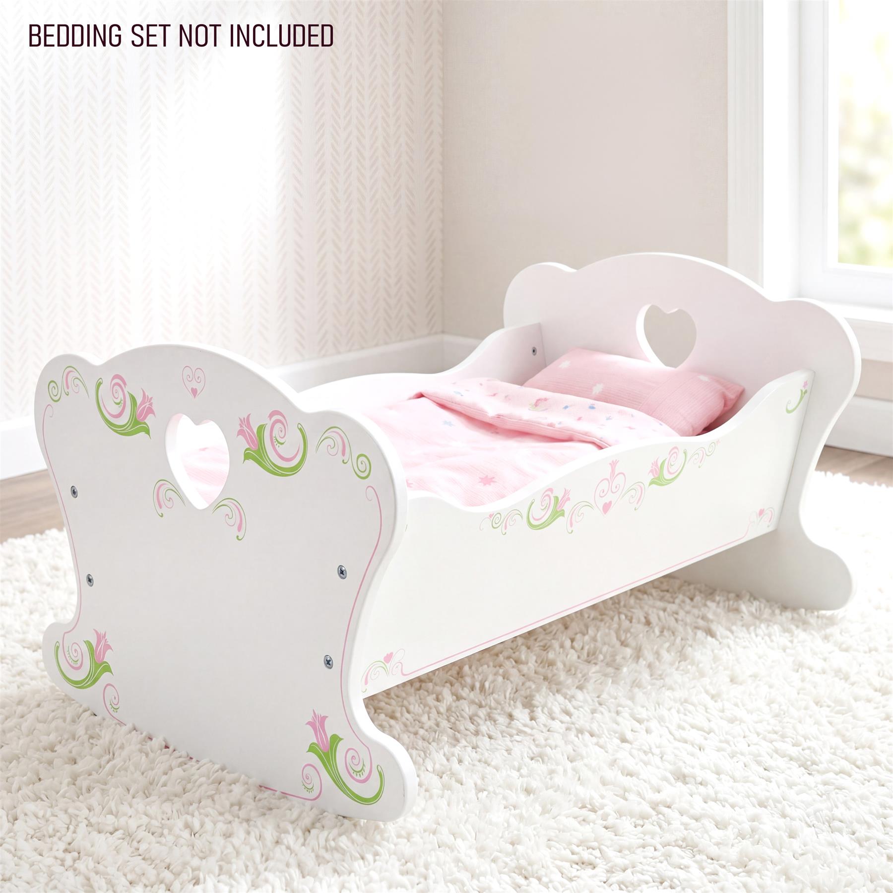 White wooden doll cradle features pink floral scrollwork, holding matching pink pillows and bedding set.