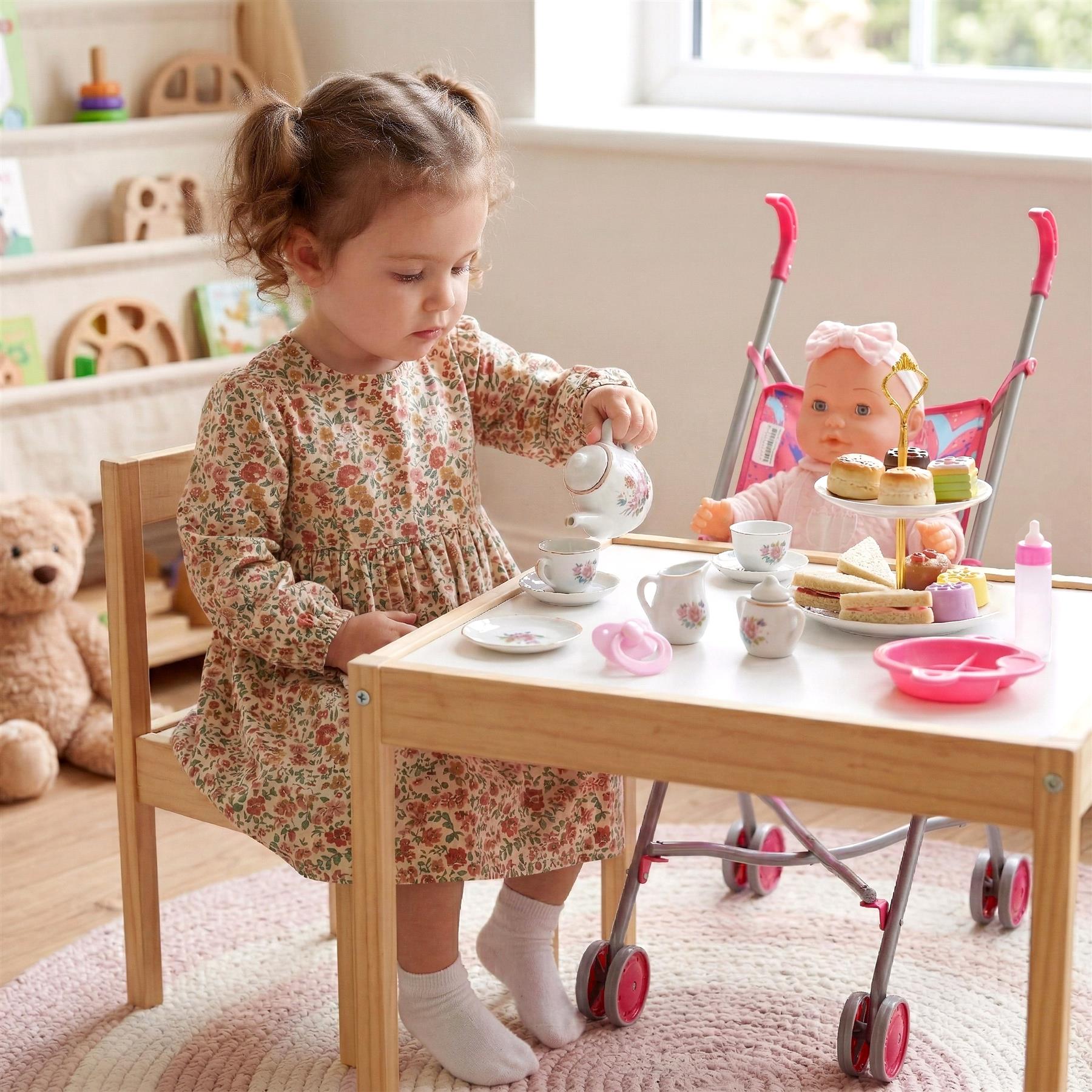 Girl playing with a doll and accessories including a tea set on a wooden toy table.