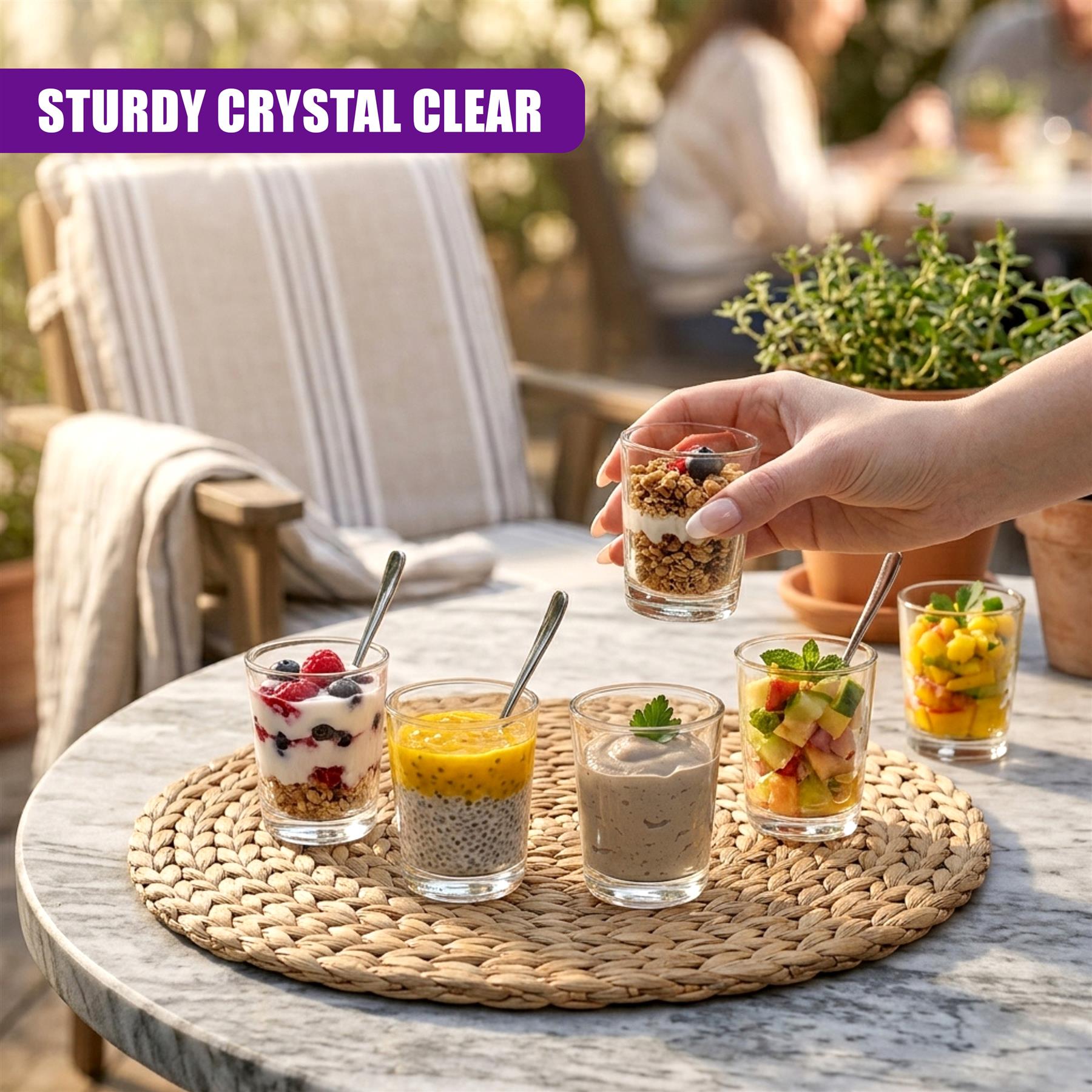Clear mini shot glasses holding colorful layered desserts are arranged on a neutral woven mat.