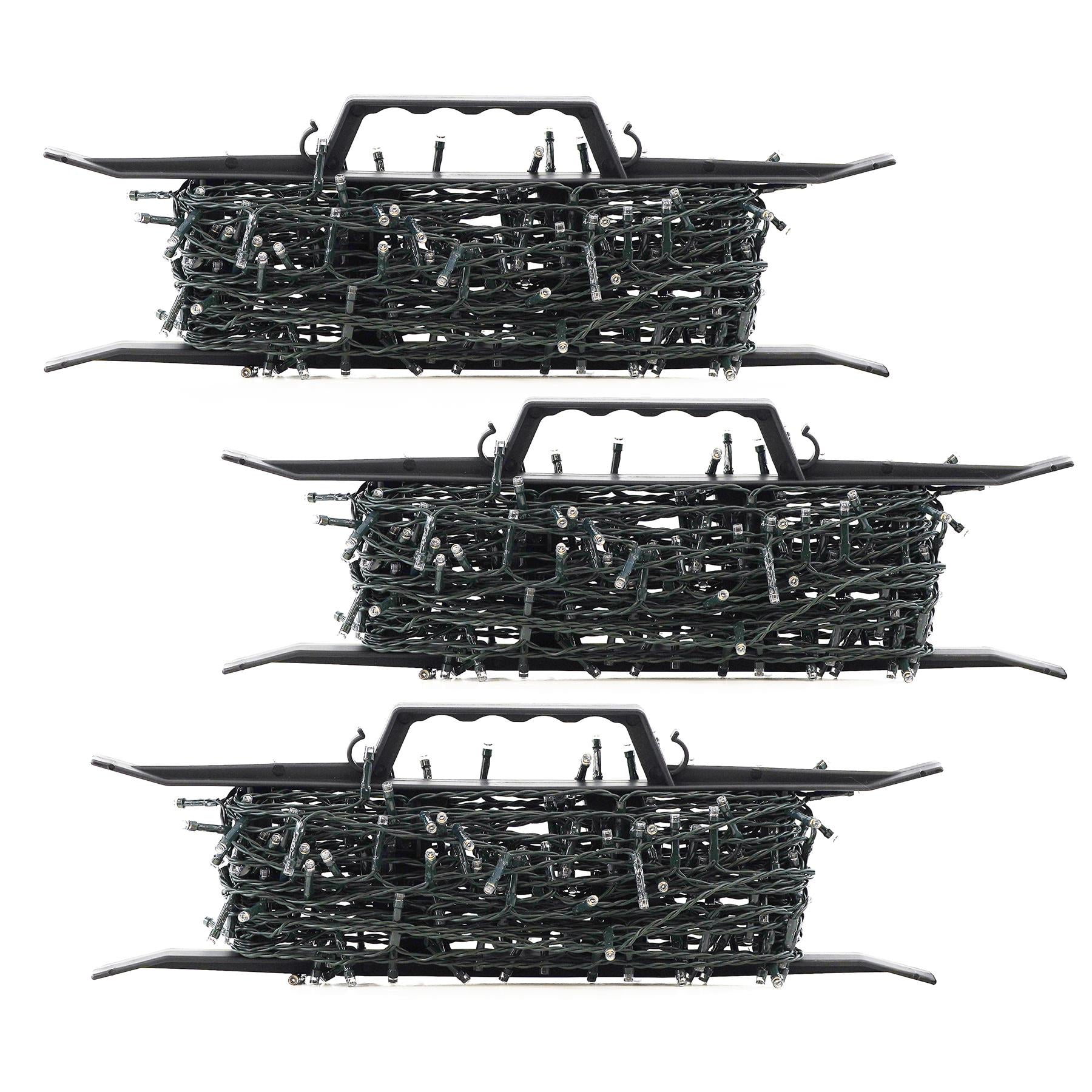 A stack of three identical, black, plastic storage containers, each filled with a tangled mass of green, plastic, and metal Christmas lights. - The Magic Toy Shop