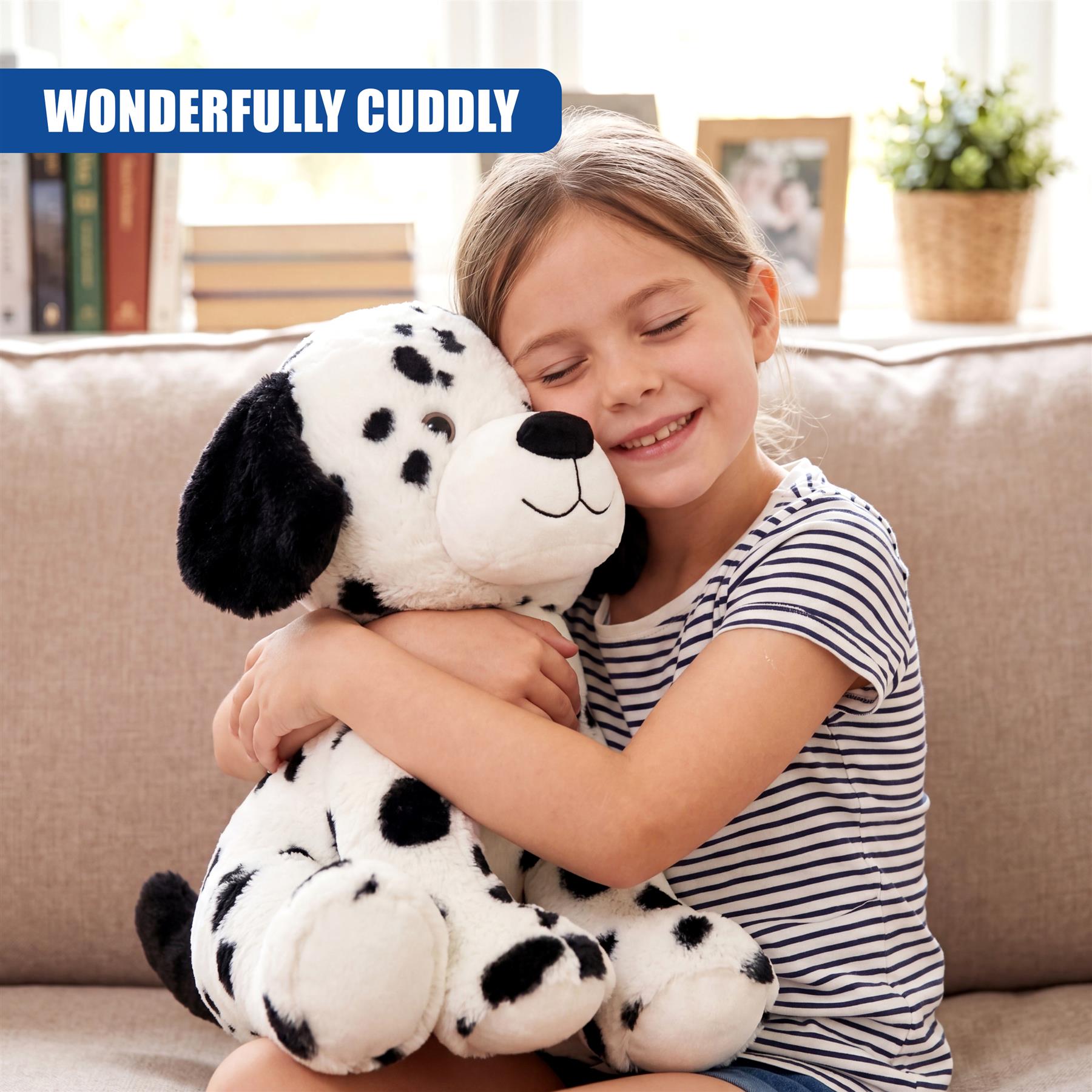 A child hugging a stuffed Dalmatian dog toy with black spots on a couch.
