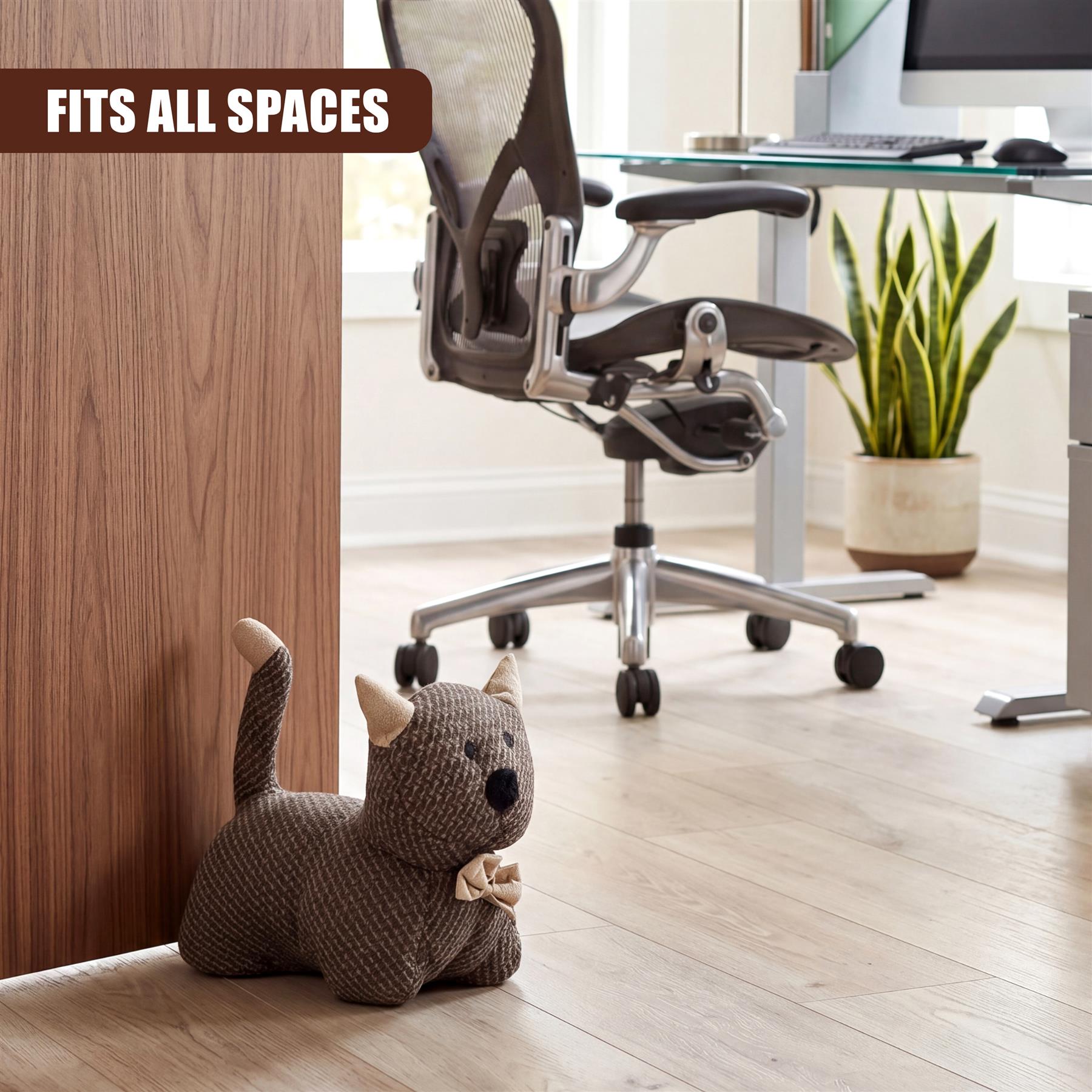 Knitted gray kitten door stopper rests against light wood paneling near an office chair setup.