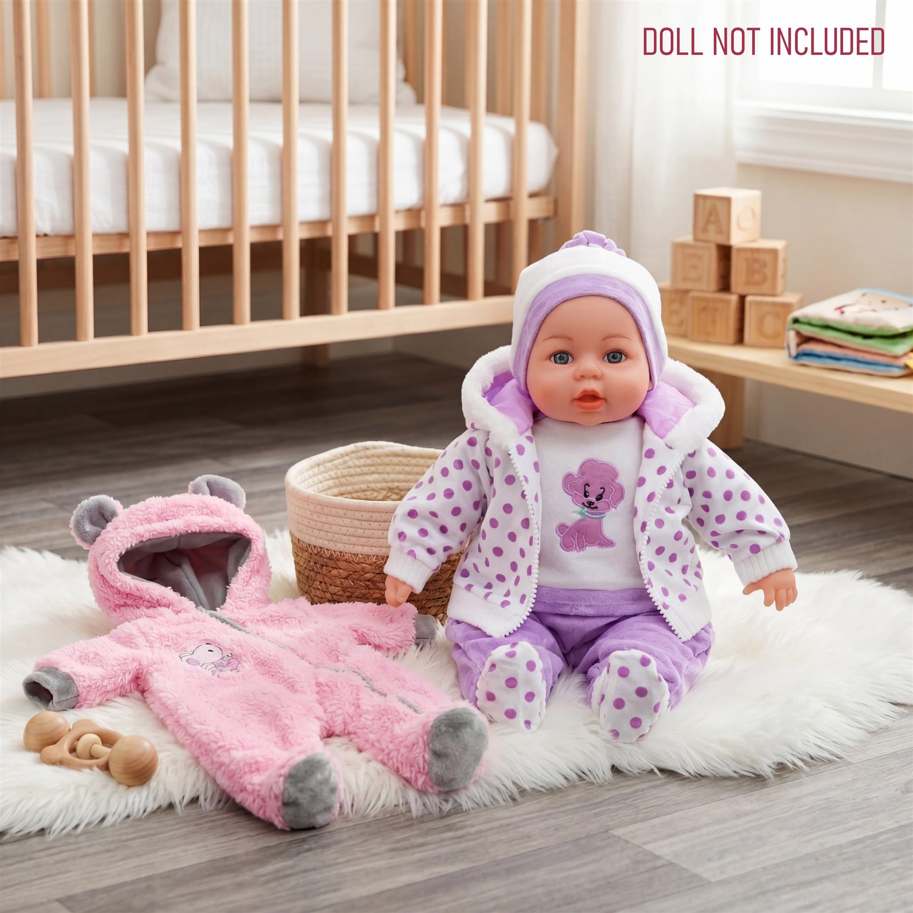 A doll wearing purple clothing sits near a pink hooded costume and a woven basket.