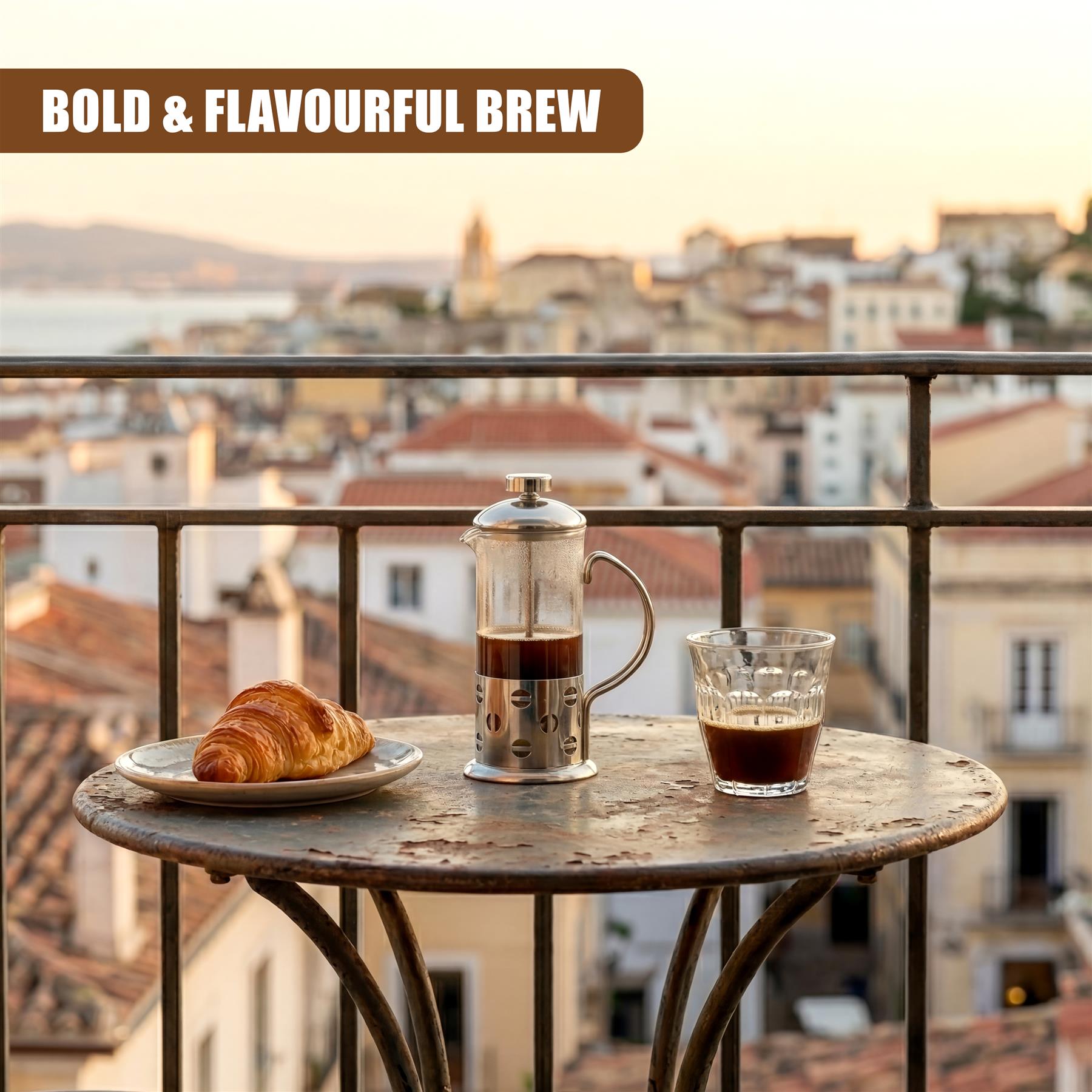 A cafetiere, a glass of brewed coffee, and a croissant rest on a round metal table.