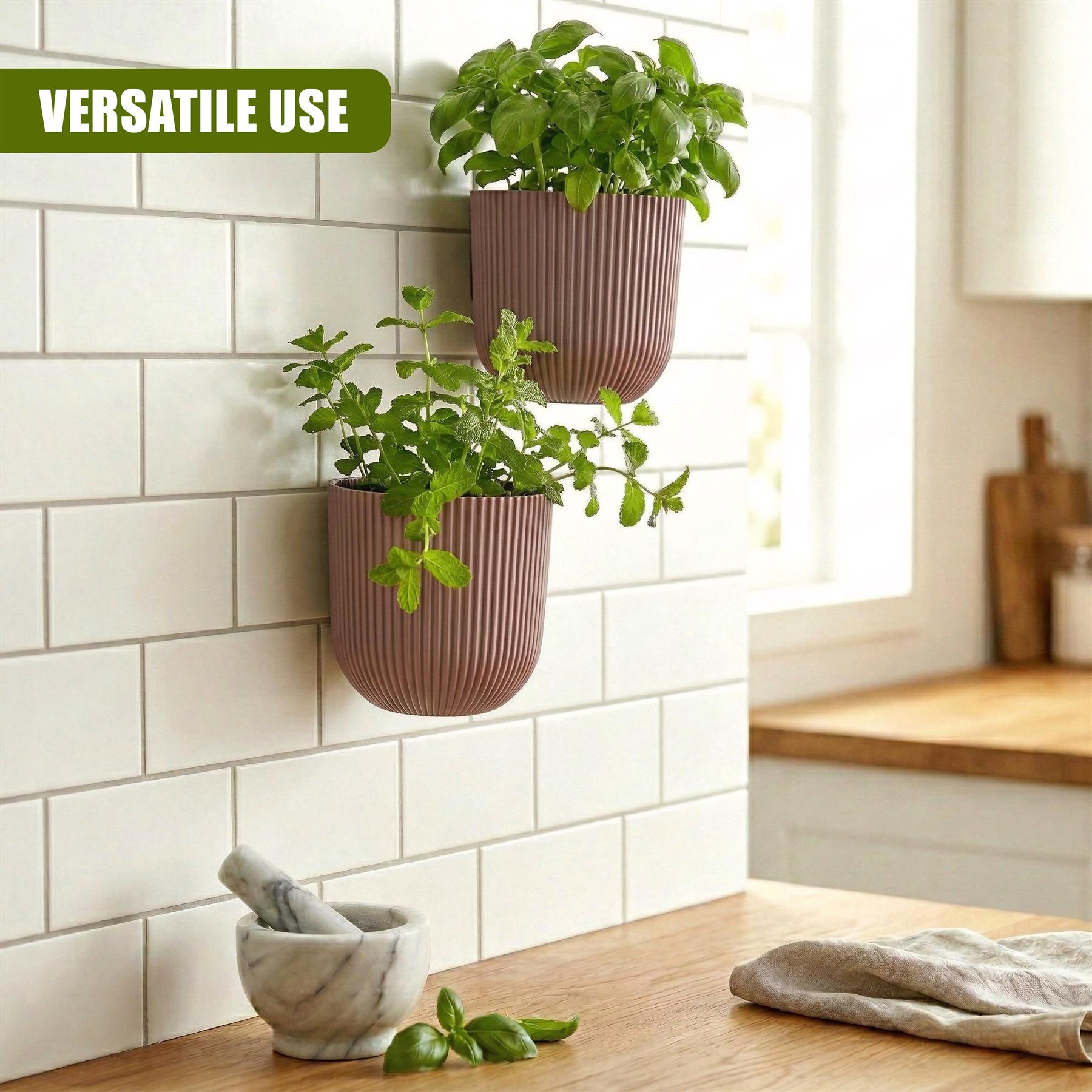 Two ribbed wall planters hold fresh green plants against a white subway tile kitchen background.