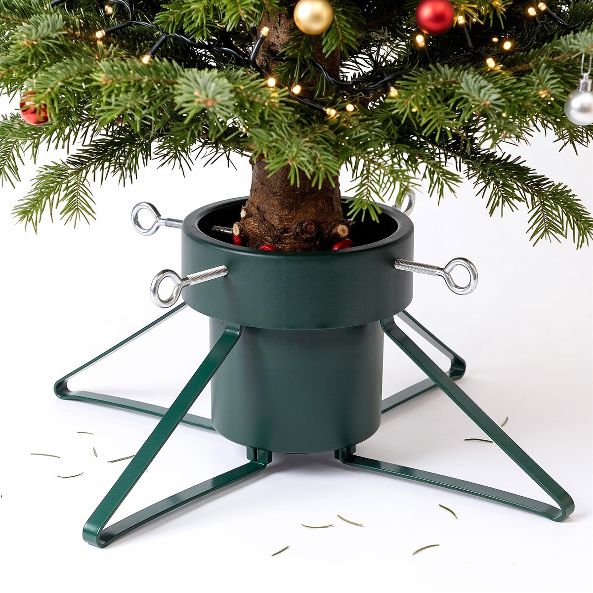 Green metal Christmas tree stand with a tree and adjustable support legs