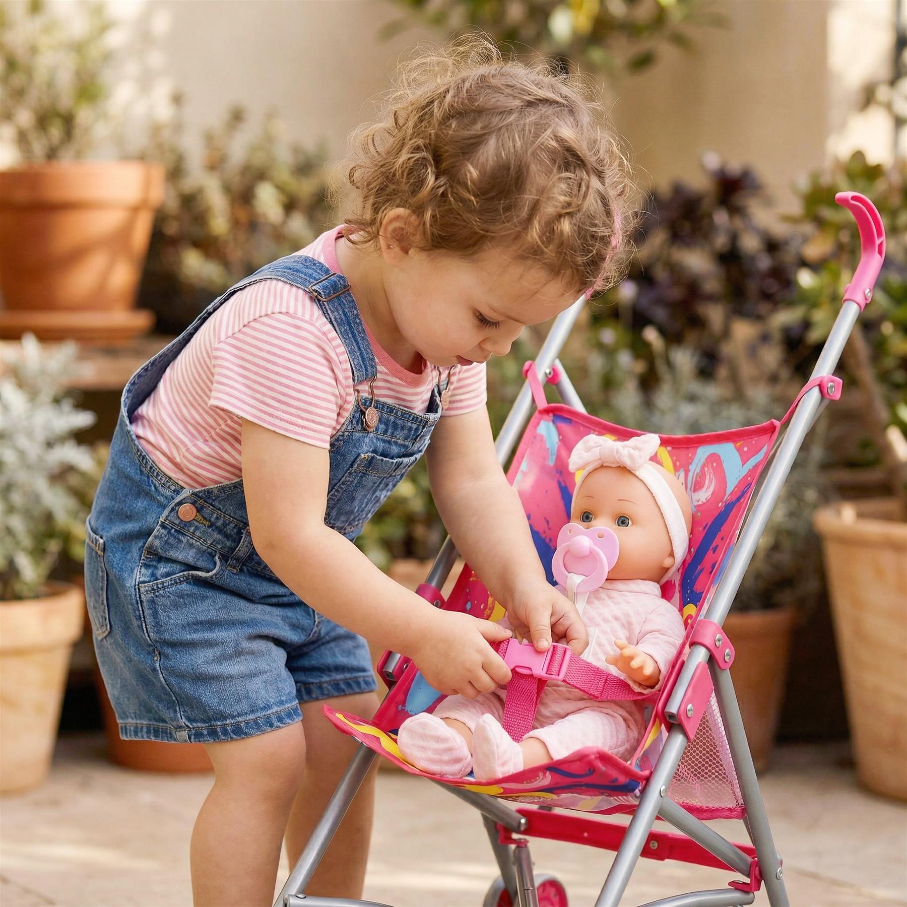 Child interacting with a doll seated in a pink toy buggy among potted plants.