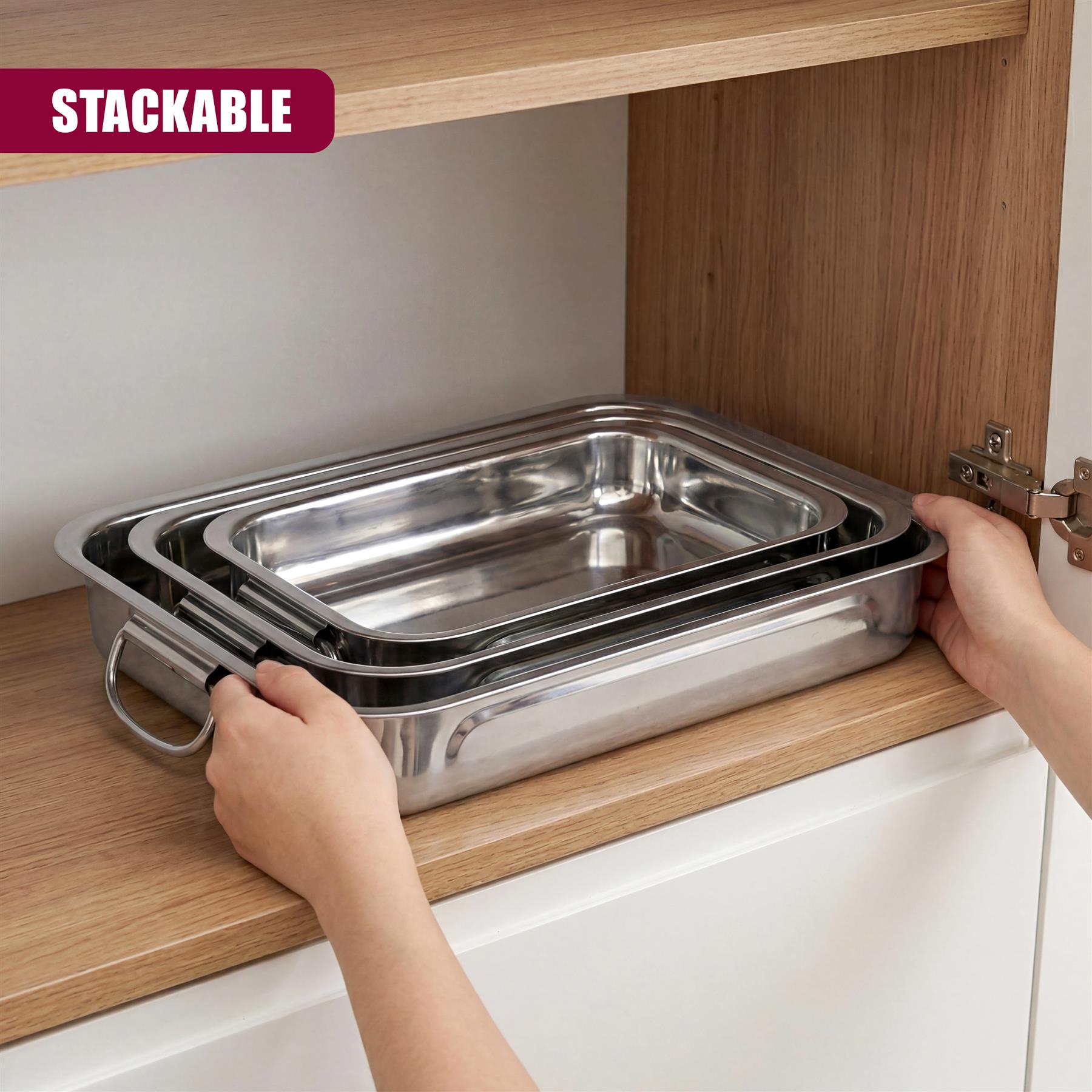 Stacked set of three rectangular stainless steel trays rests on a wooden kitchen shelf.