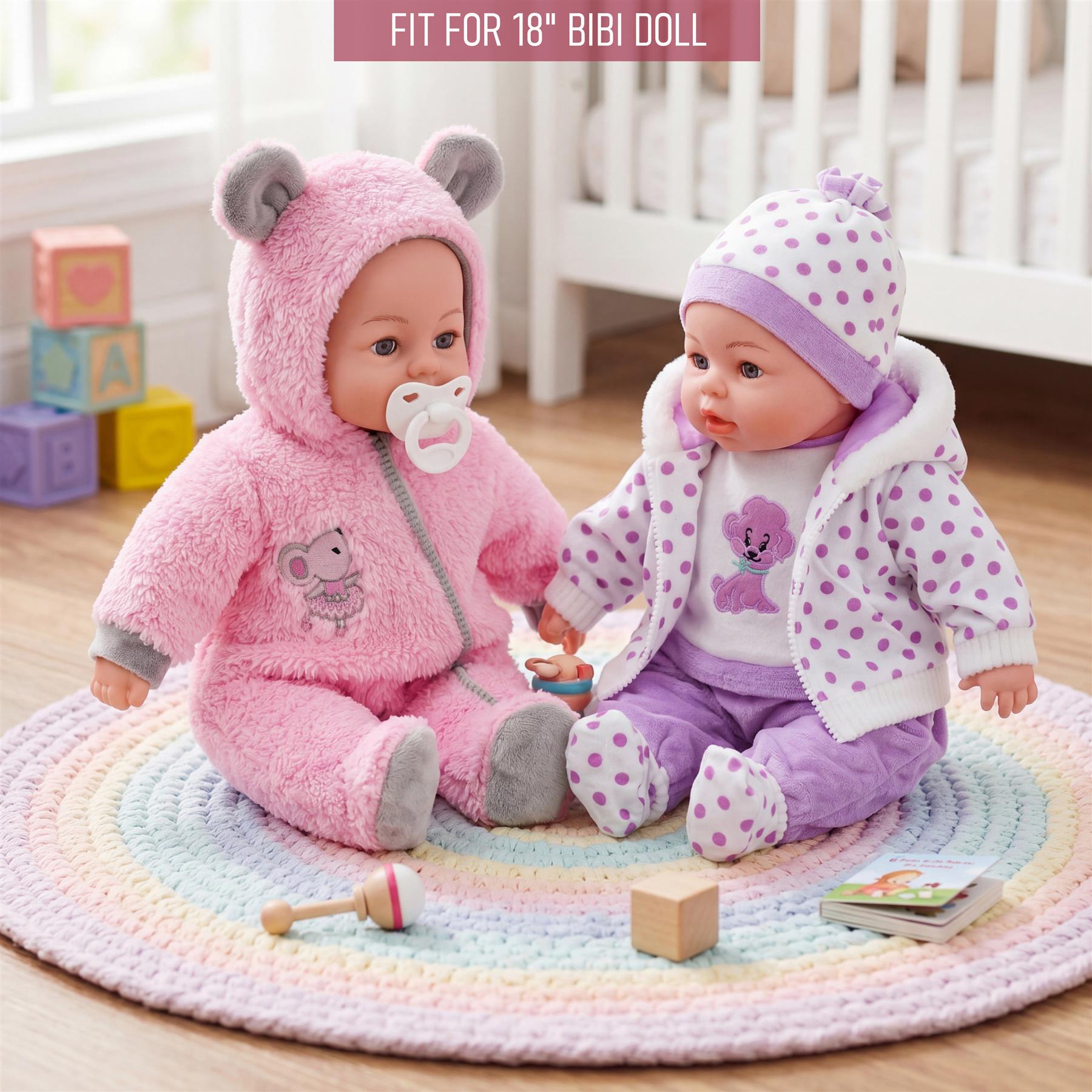Two dolls in pink and purple outfits sit on a rainbow mat with small blocks and toys.