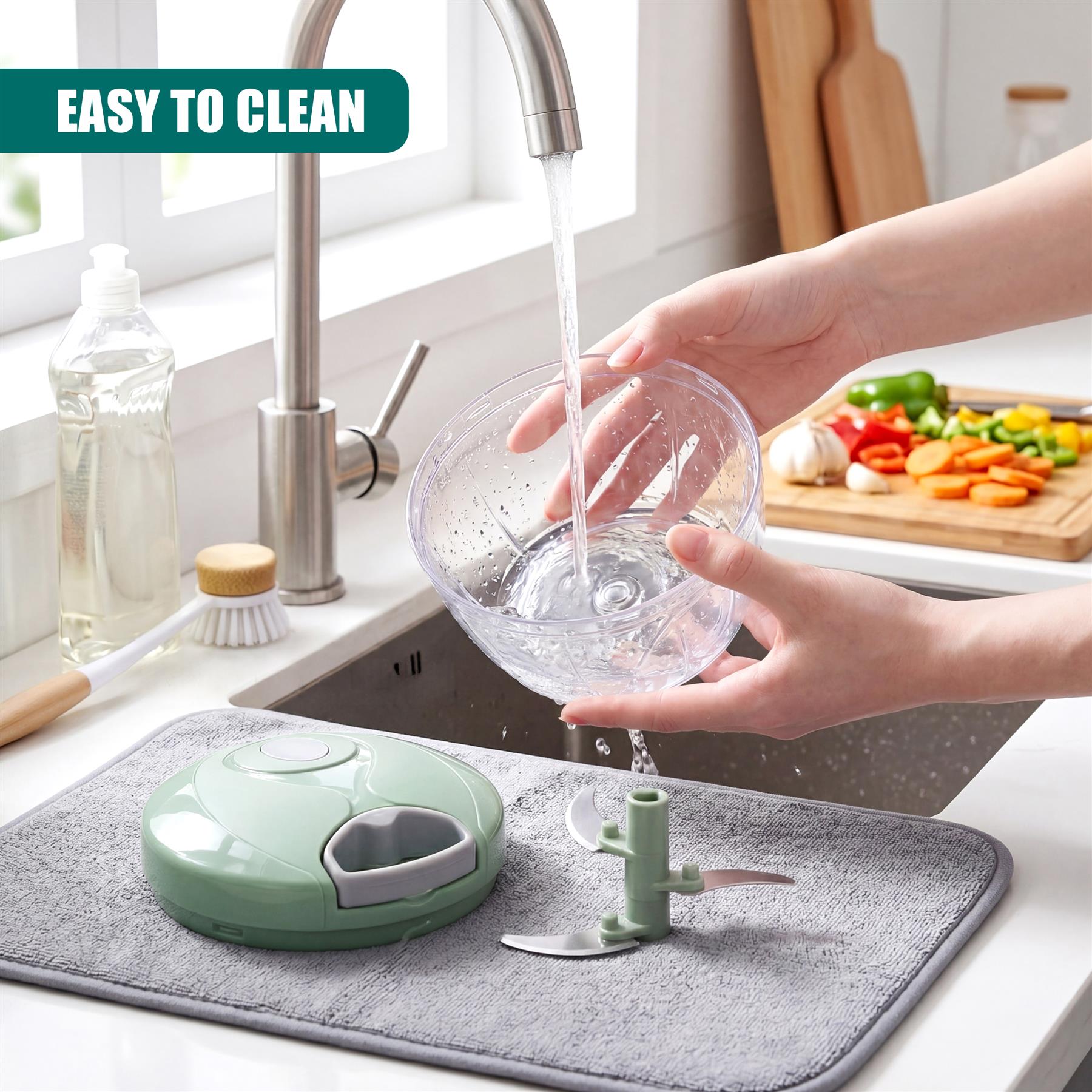 A green manual food chopper rests on a gray mat next to a kitchen sink and running faucet.
