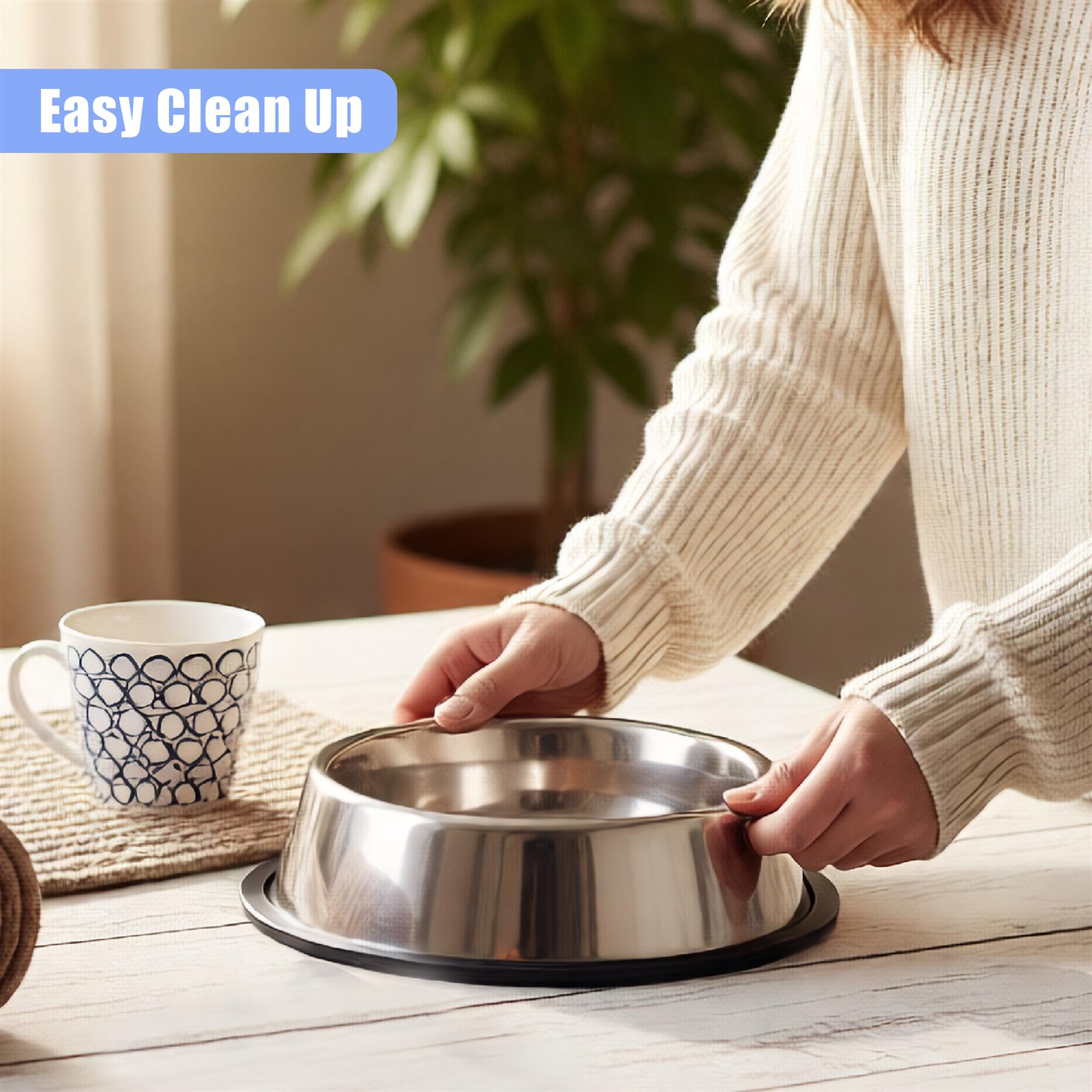 A stainless steel dog bowl with a non-slip base, a woman's hands placing a dog's food into the bowl, and a cup of coffee on the table in the background. - The Magic Toy Shop