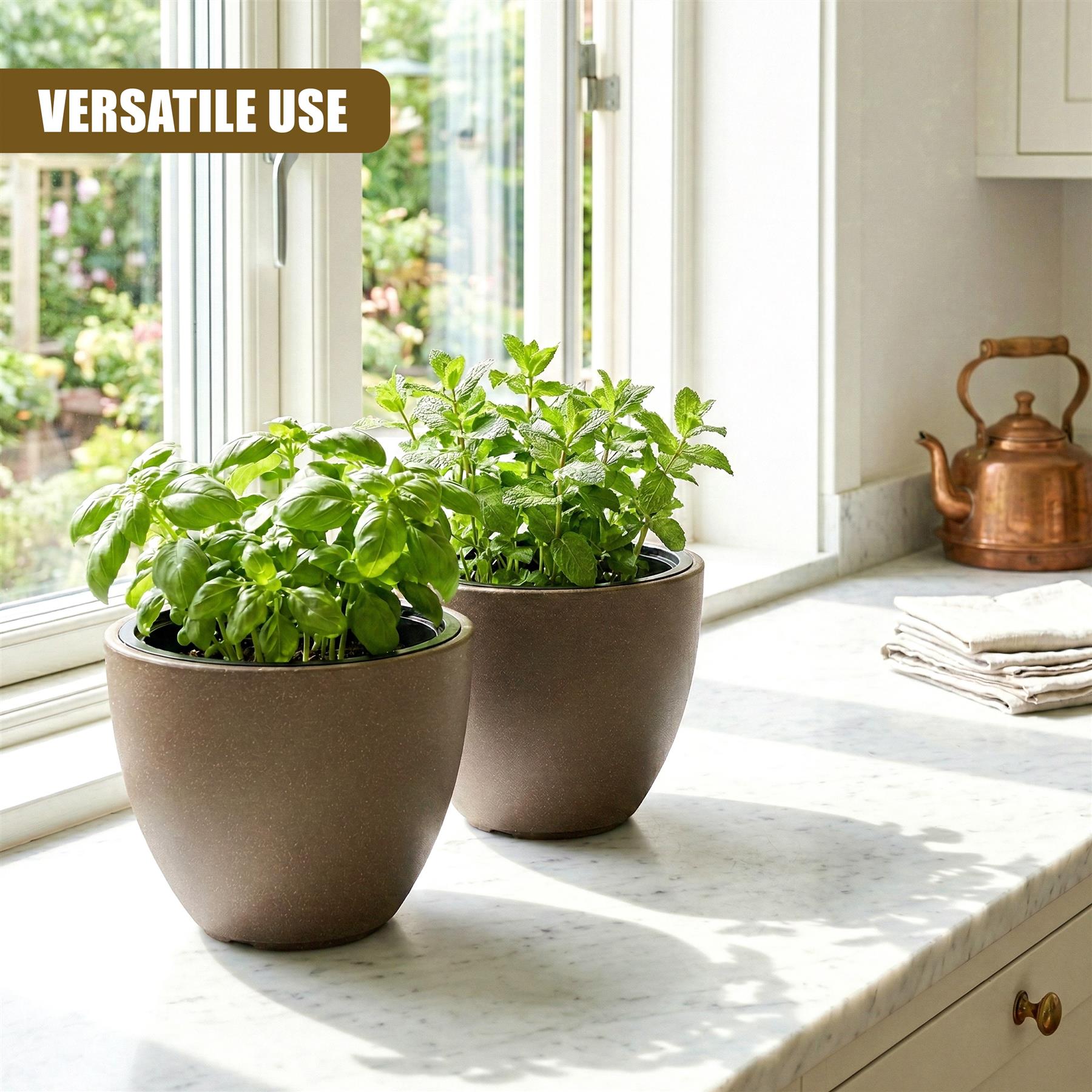 Two smooth, brown oval pots display vibrant green foliage on a light-colored countertop near a window.
