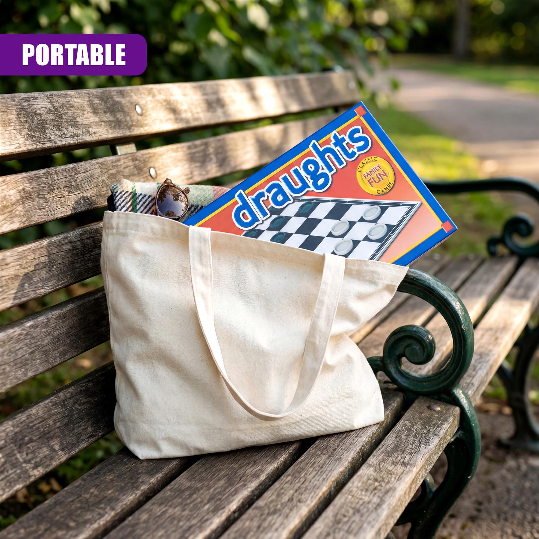 Canvas tote bag holding a folded draughts game board rests on a wooden outdoor bench.