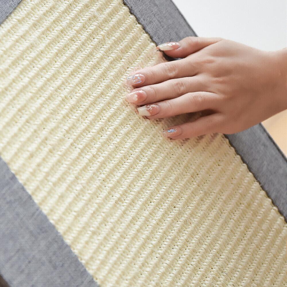 A hand with long, pale pink nails gently touches a soft, cream-colored rug with a subtle, textured pattern. - The Magic Toy Shop
