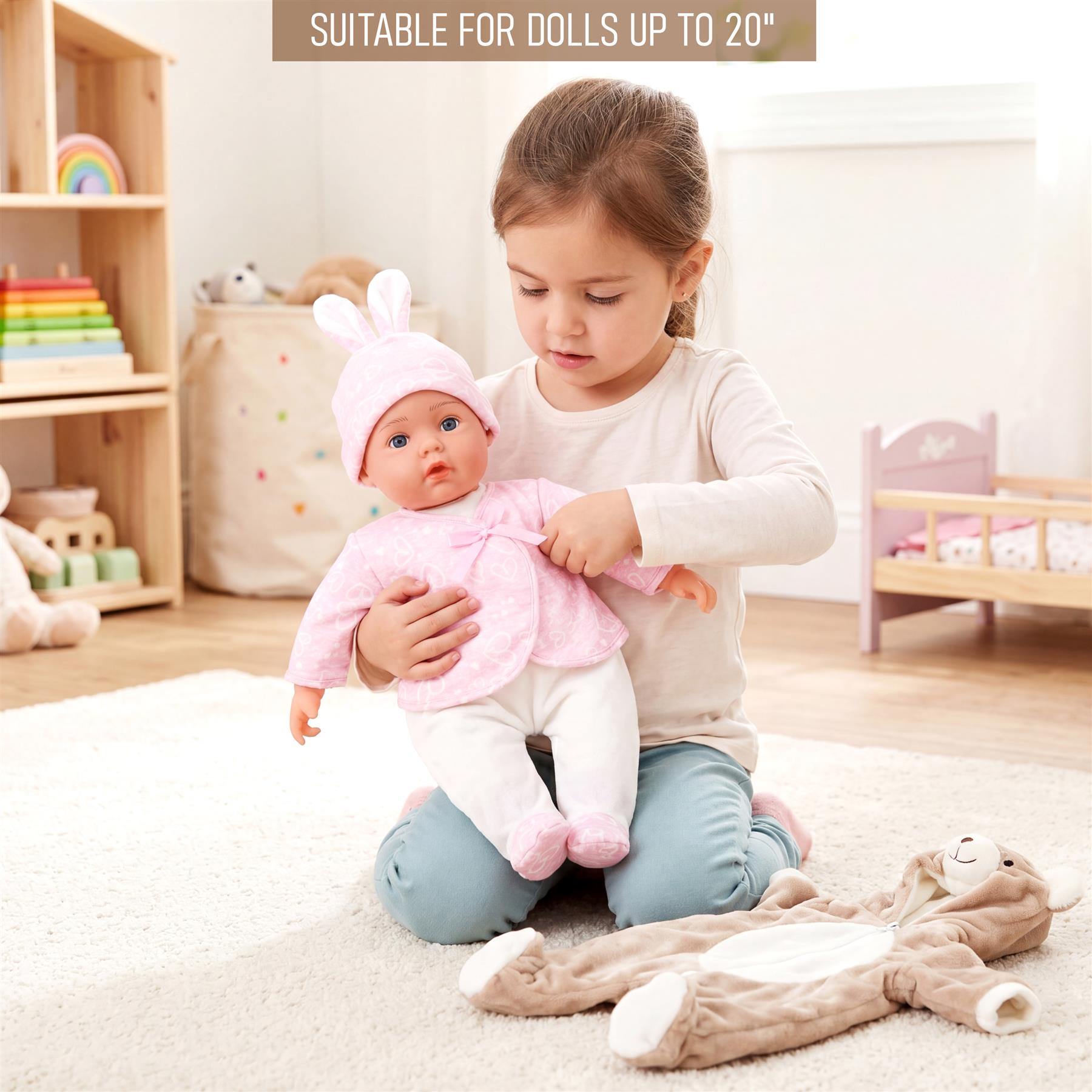 A young girl holds a doll wearing a pink bunny outfit near plush stuffed animals.