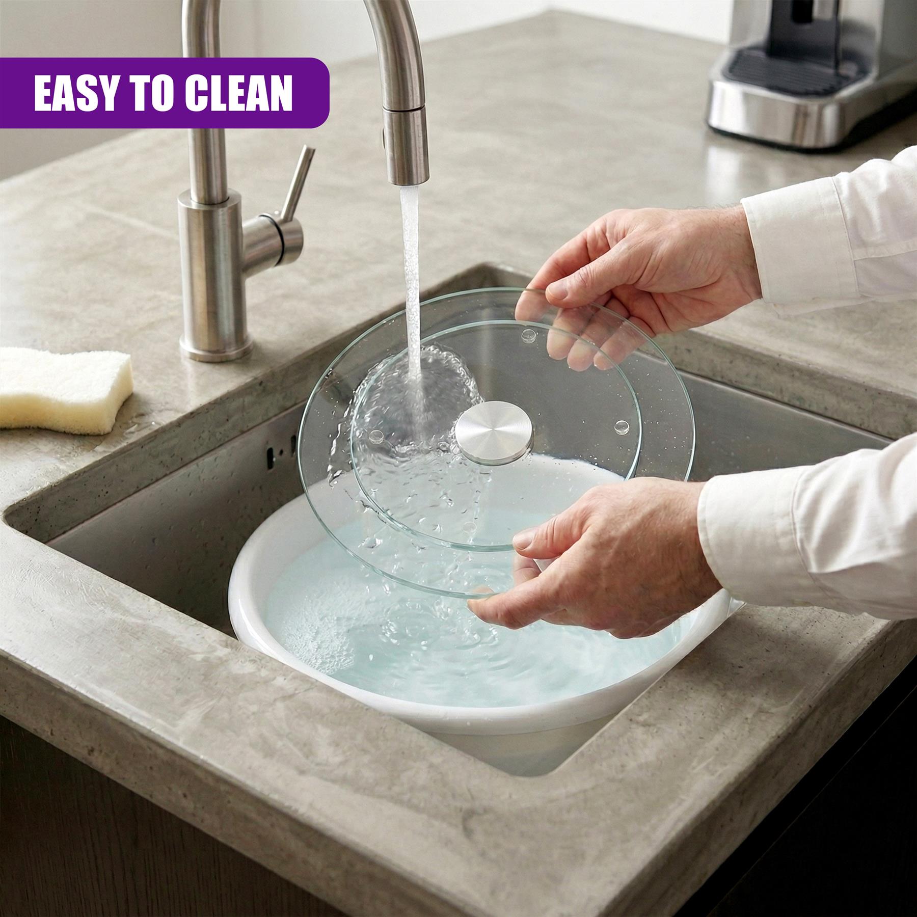 Clear glass turntable being washed in a sink with running water from the faucet.
