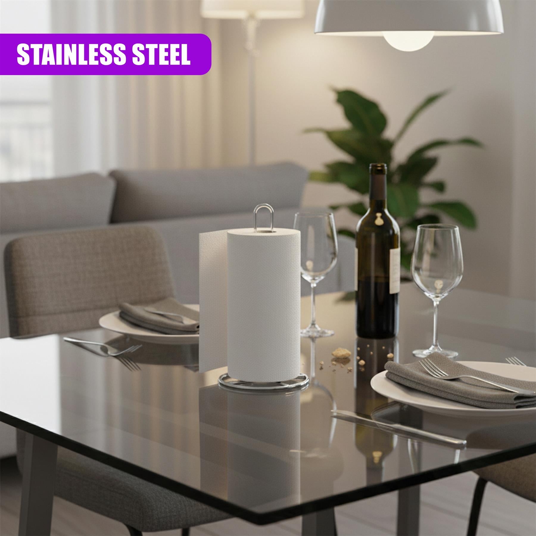 The stainless steel roll stand rests on a glass table among wine glasses and silverware settings.