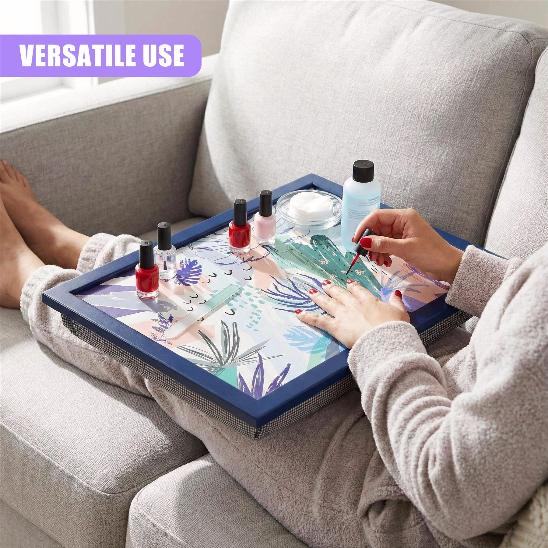 A lap tray featuring a blue palm leaf design holds nail polish and various cosmetic products.