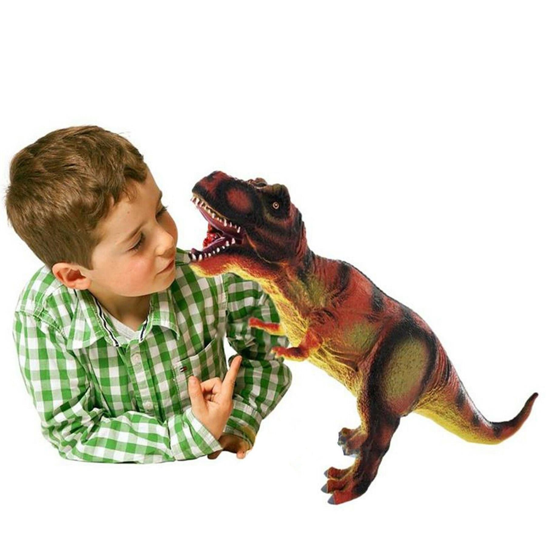 A young boy in a checkered shirt holds a soft, reddish-brown toy dinosaur.