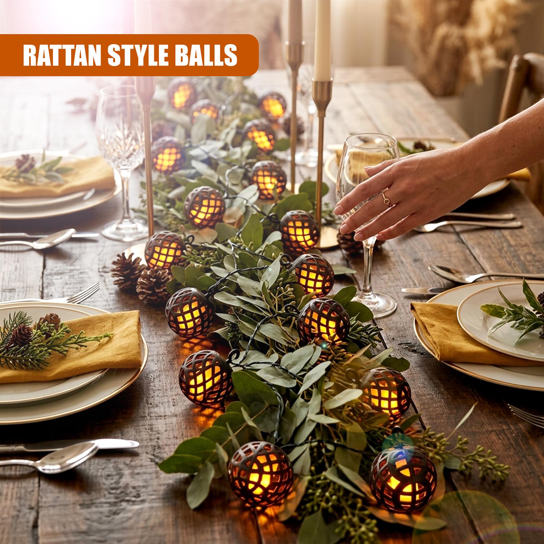 Solar rattan light balls draped over leaves, decorating a rustic wooden table centerpiece with tableware.