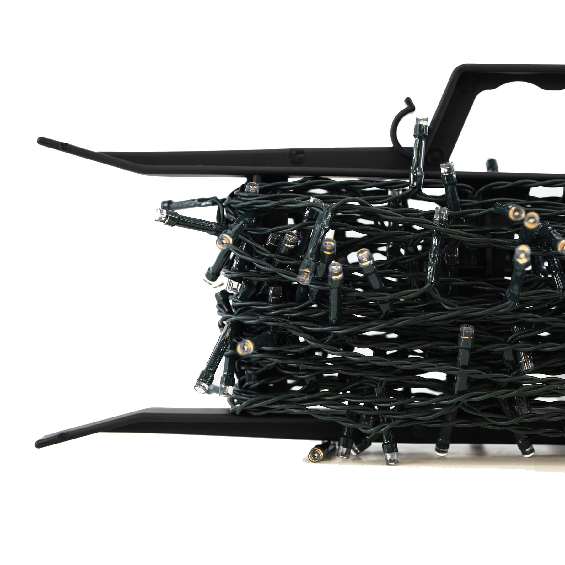 A close-up of a set of Christmas lights, featuring a compact, black, and flexible design, with a black plastic housing and a long, thin, and flexible cable, with multiple small, white, and clear lights, and a small, round, and yellow-tinged light at the end of each cable, all contained within a small, black, and plastic storage case. - The Magic Toy Shop