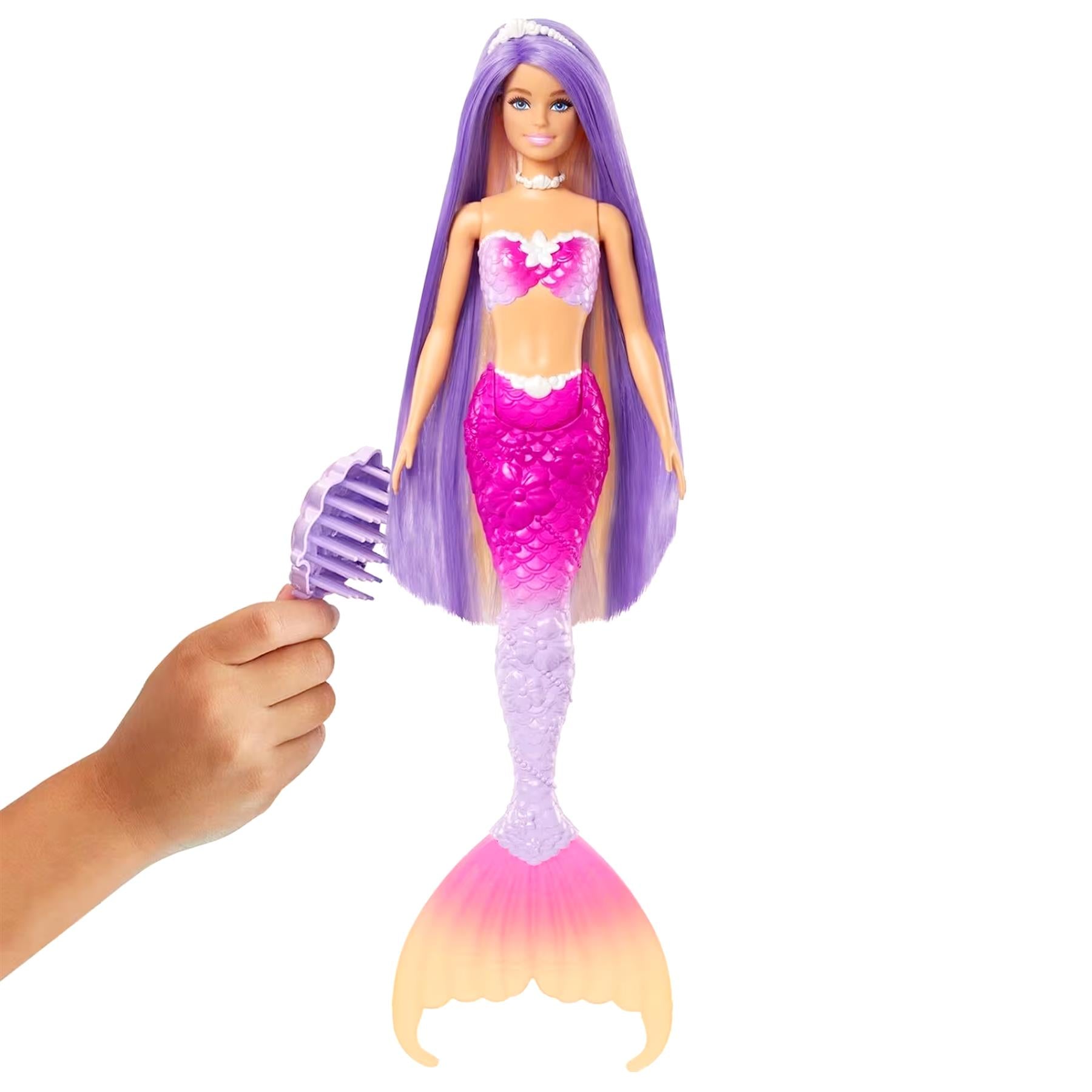 A hand combs the purple hair of a doll dressed as a mermaid.