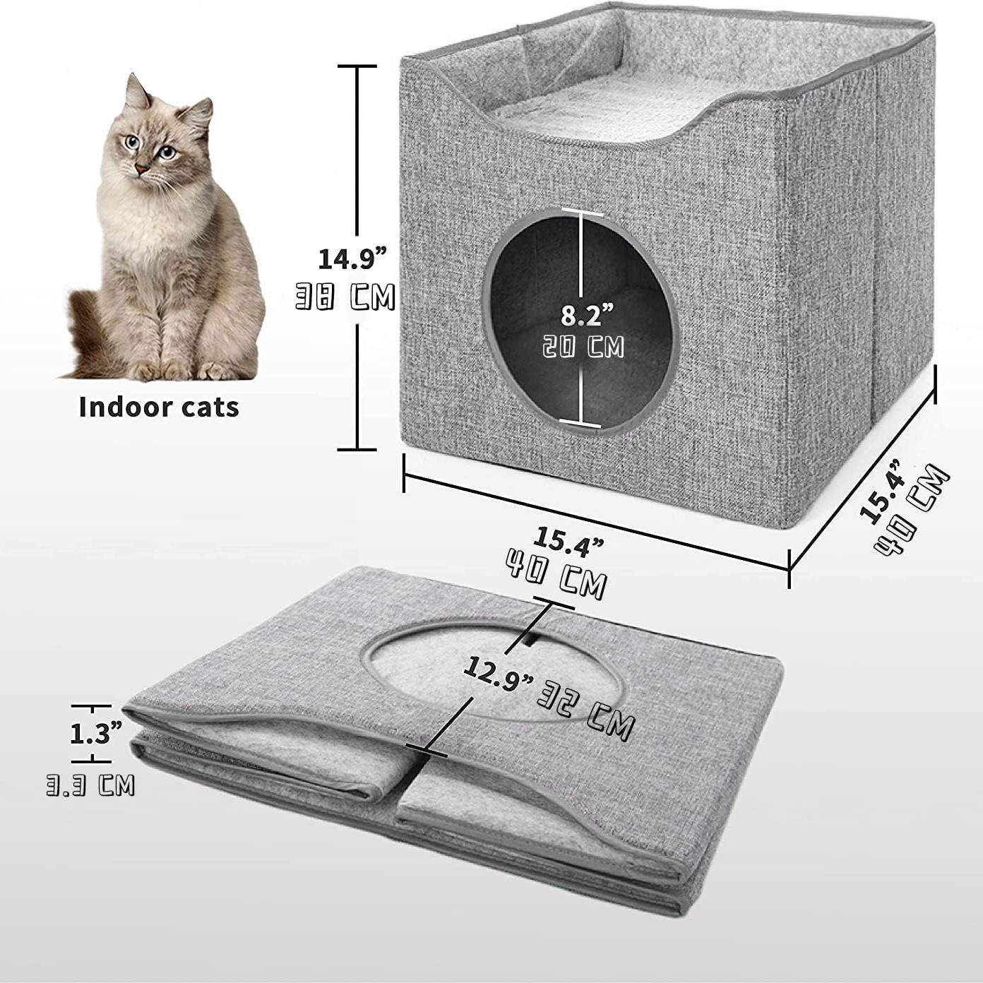 A grey, square cat bed with a circular hole in one side, made of soft, grey fabric. The bed has a flat, flat top and a slightly curved, rounded edge. A cat is sitting in the bed, looking directly at the camera. The bed is surrounded by a white background. - The Magic Toy Shop