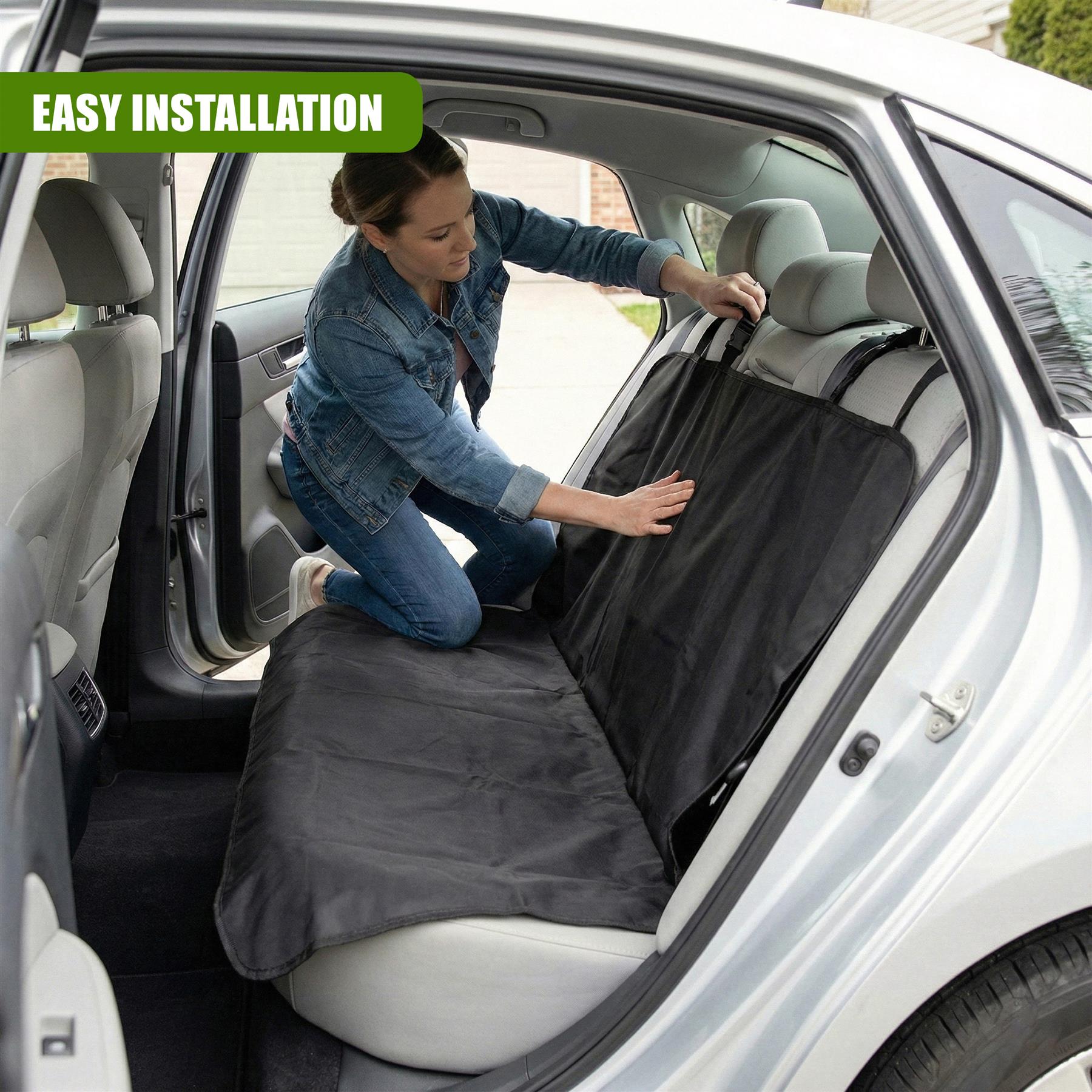 A woman is seen installing a black car seat protector on the back seat of a white car. The seat protector is a large, flat, black piece of fabric with a Velcro strap to secure it to the seat. - The Magic Toy Shop