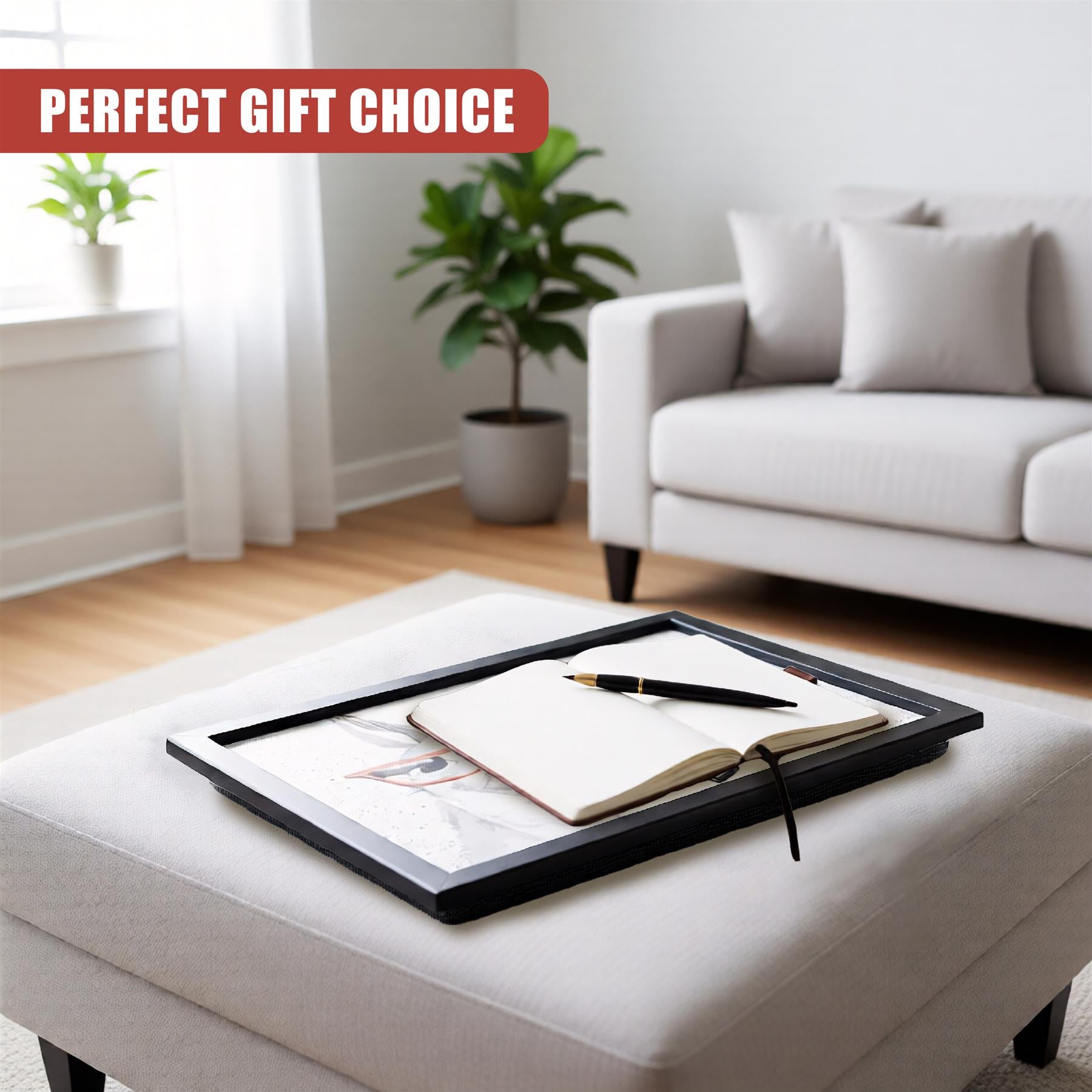 Open notebook and black pen rest on a rectangular black serving tray placed on upholstery.