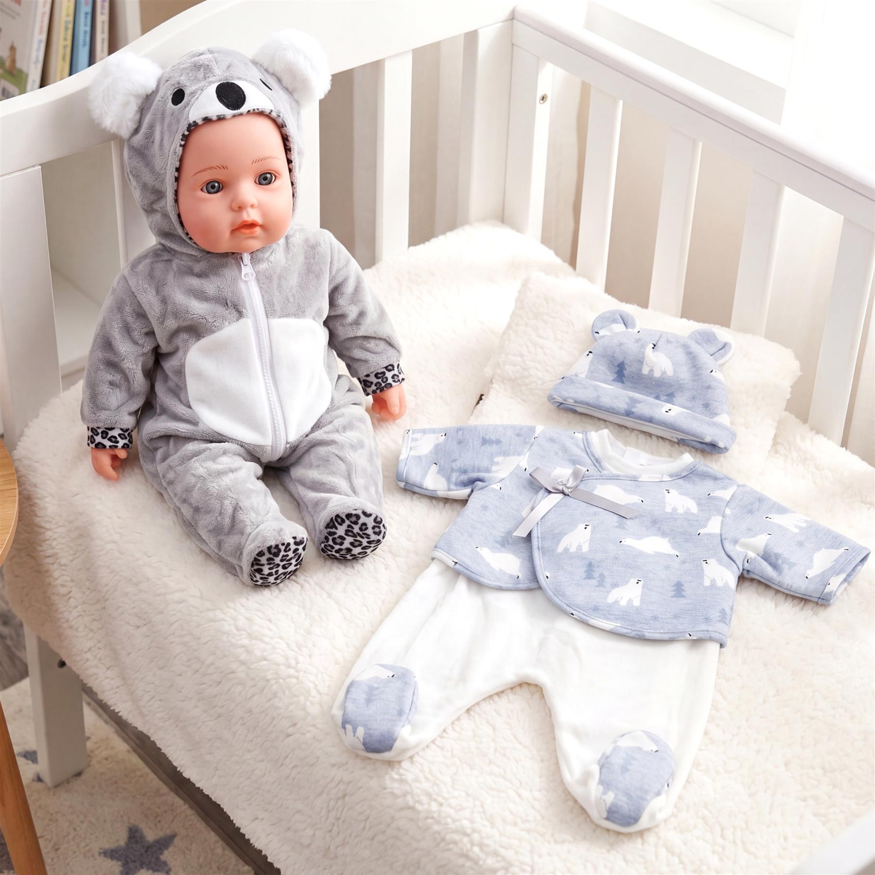 A doll in a gray hooded outfit displayed with blue patterned baby clothing set.