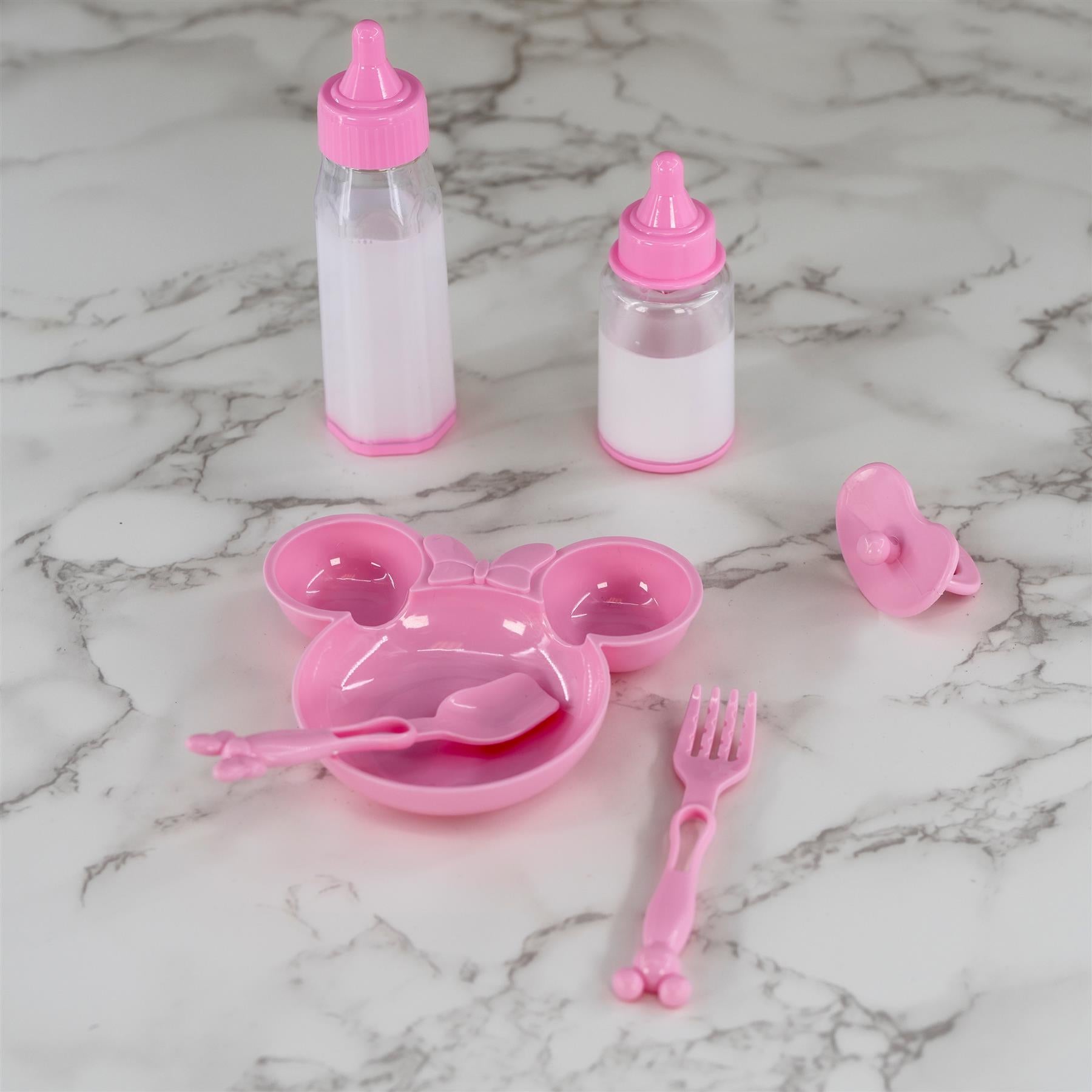Plastic doll feeding accessories including two bottles, a Mickey plate, a fork, and a small accessory piece.