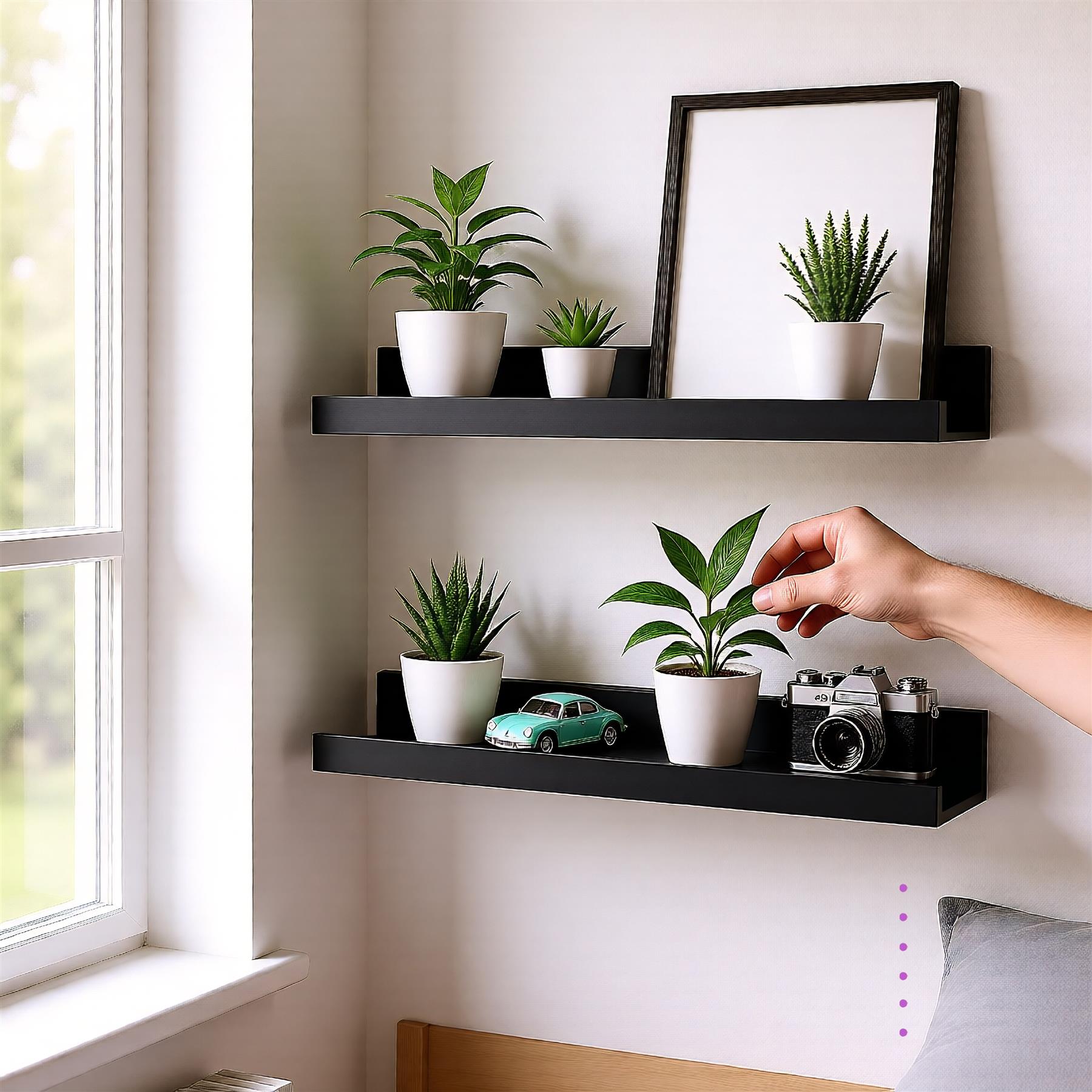 A person's hand reaches out to touch a plant on a shelf. The shelf has two black shelves, one above the other, with plants and other objects on each. The wall behind the shelves is white. - The Magic Toy Shop
