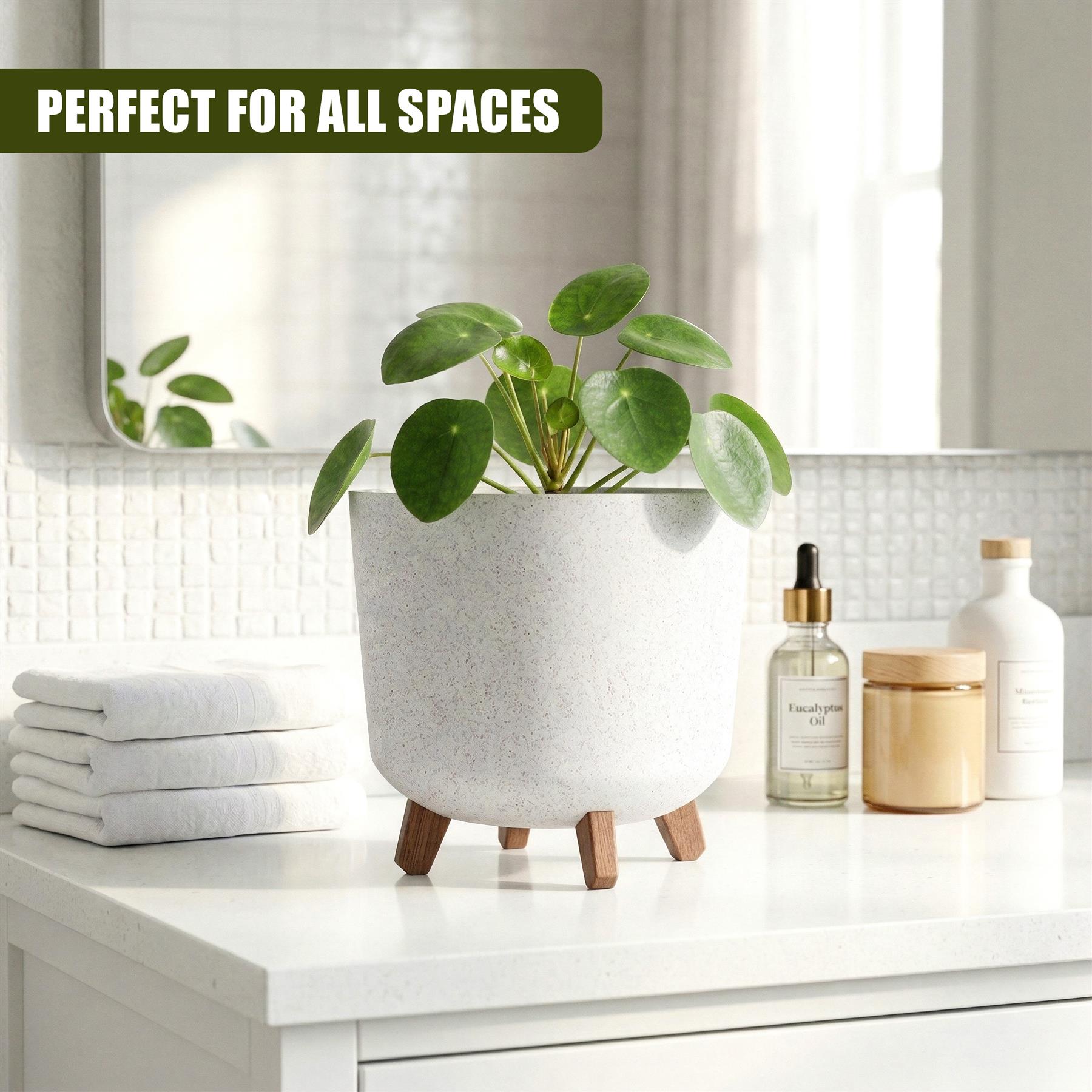 Speckled white ceramic pot with wooden legs, displaying a small green houseplant on a counter.