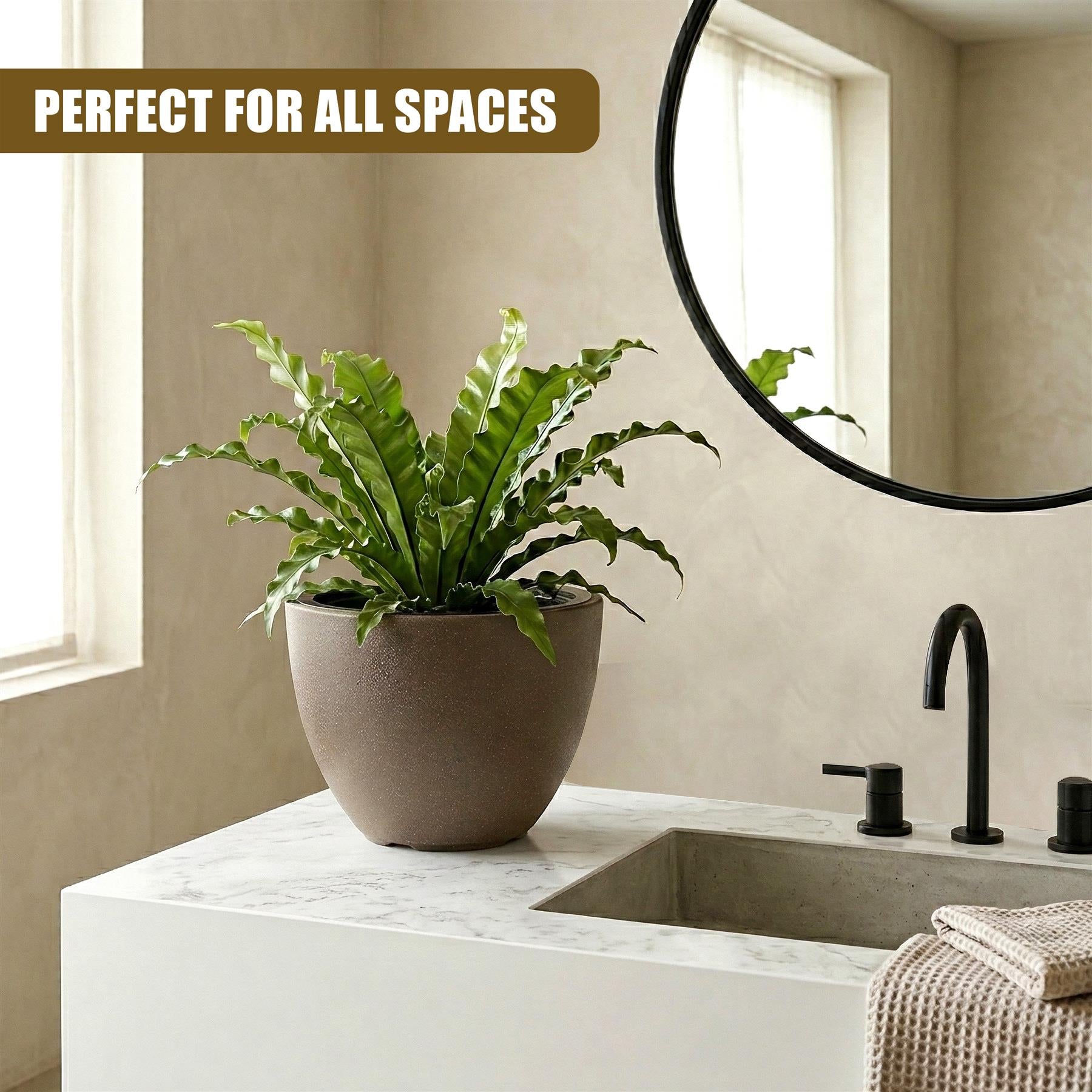 A medium brown, rounded flower pot holds a vibrant green potted plant on a white sink counter.