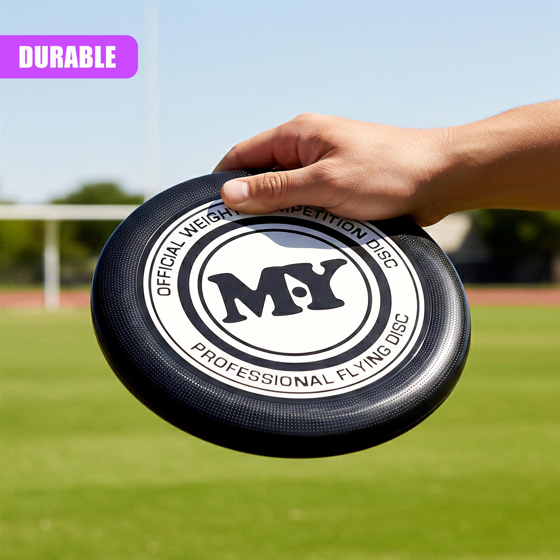 Hand holds a black professional flying disc featuring white text and the central MY logo.