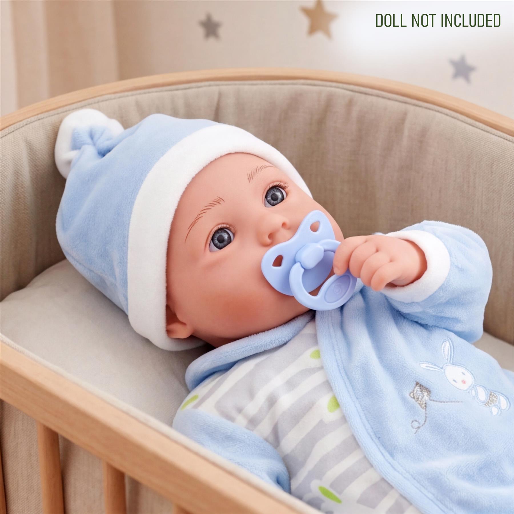 A doll is displayed in a crib wearing blue clothing and hat; the doll itself is not included.