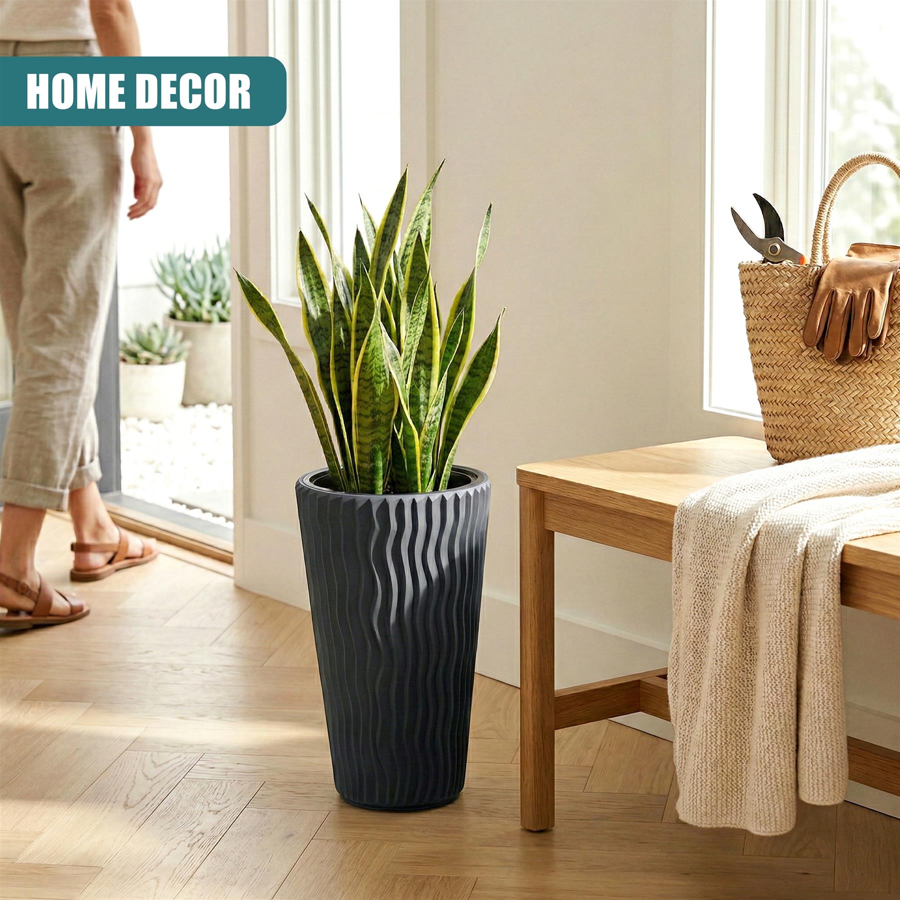 Tall, ribbed anthracite flower pot displaying green foliage next to a wooden table.