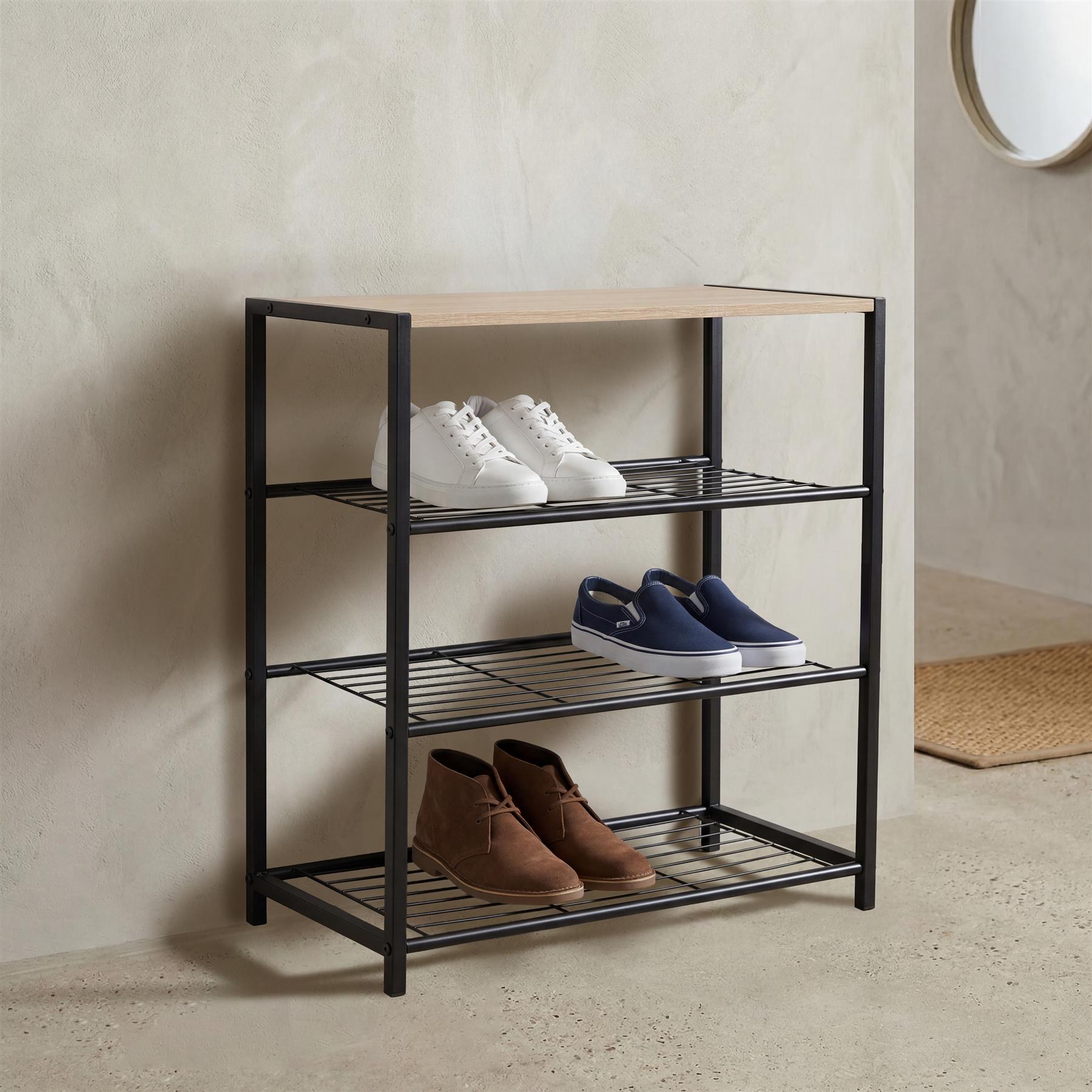 Three shelves of a black metal shoe rack display various pairs of shoes.