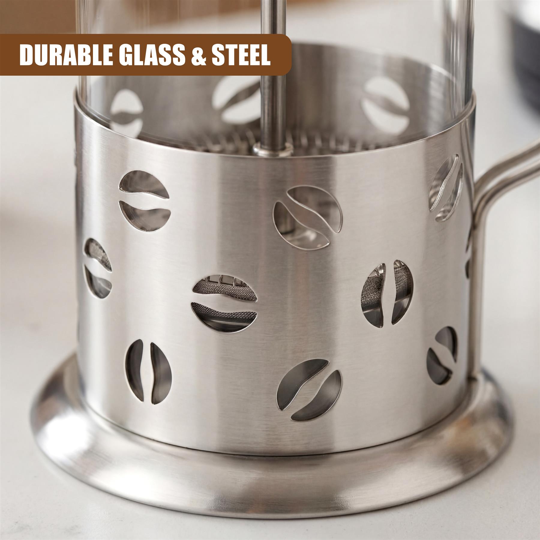Stainless steel coffee maker with perforated side and handle, resting on a base.
